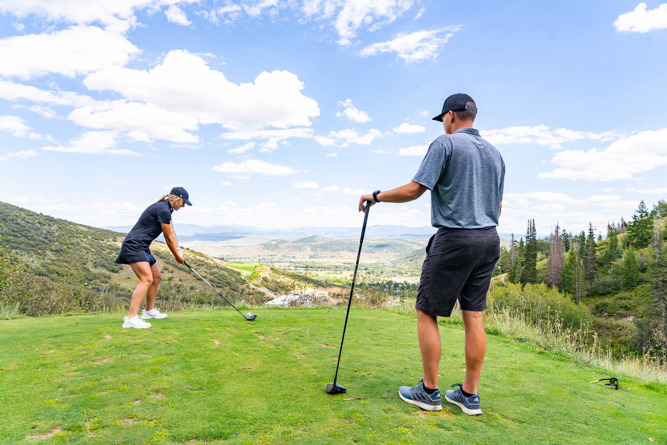 A couple tee off at Canyons Golf, Park City Mountain.