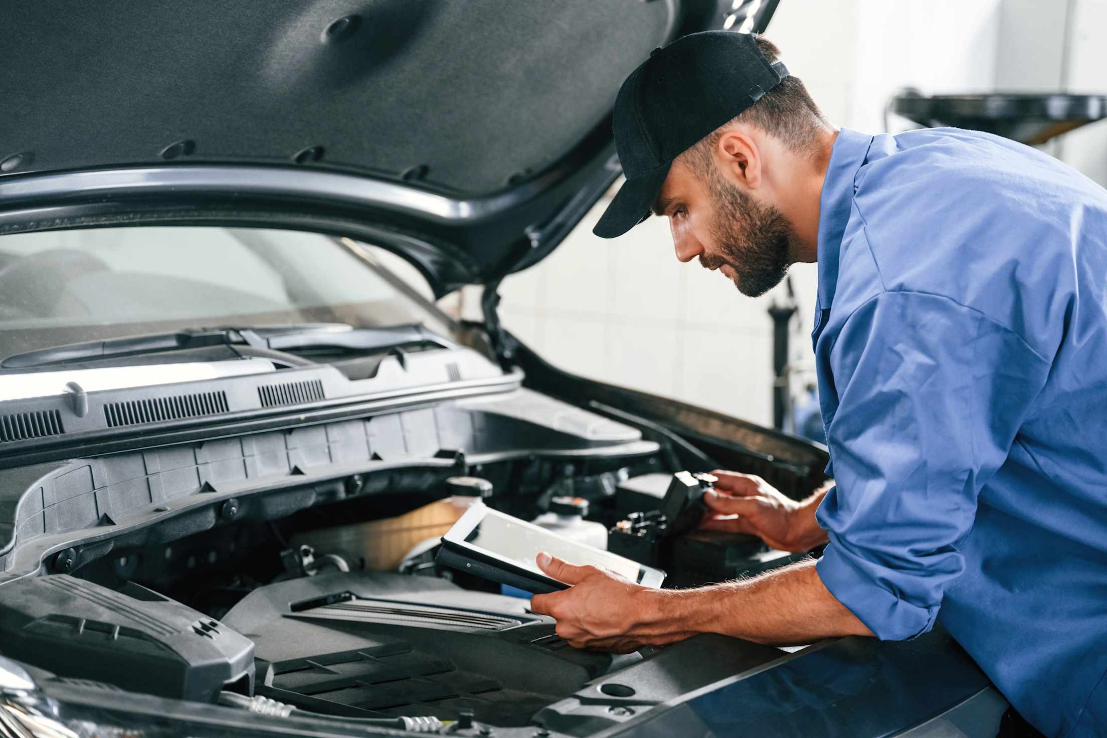 A mechanic inspects a used car.