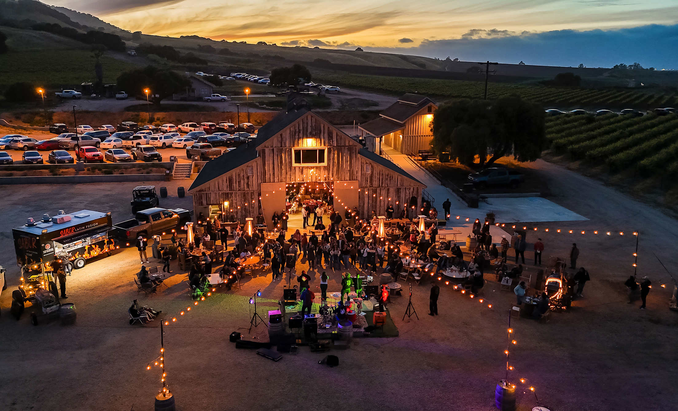 Visitors listen to live music at Rustique Wines in Salinas, California, as the sun sets.