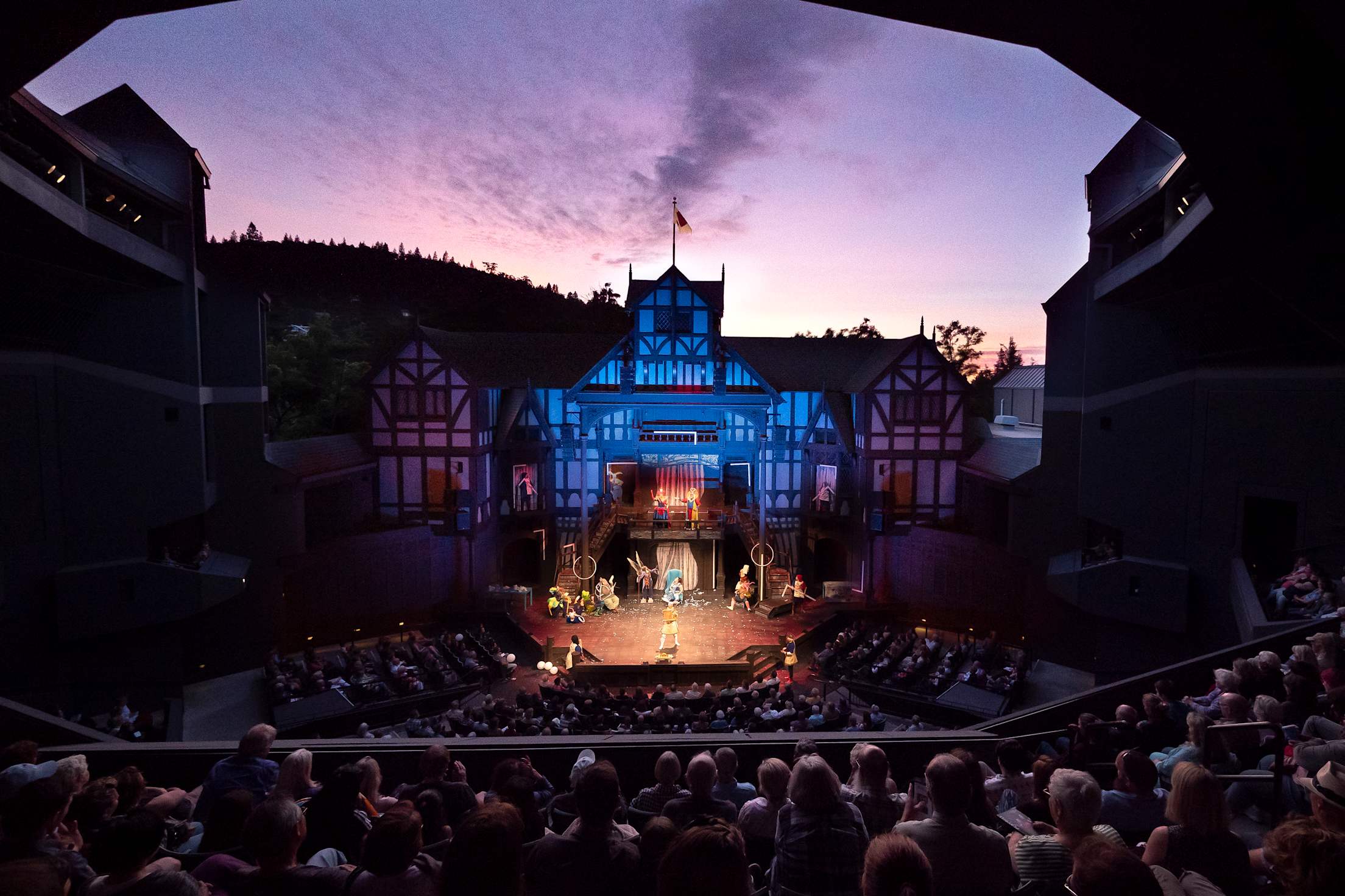 An audience watches a play at the Elizabethan Theater at dusk in Ashland, Oregon.