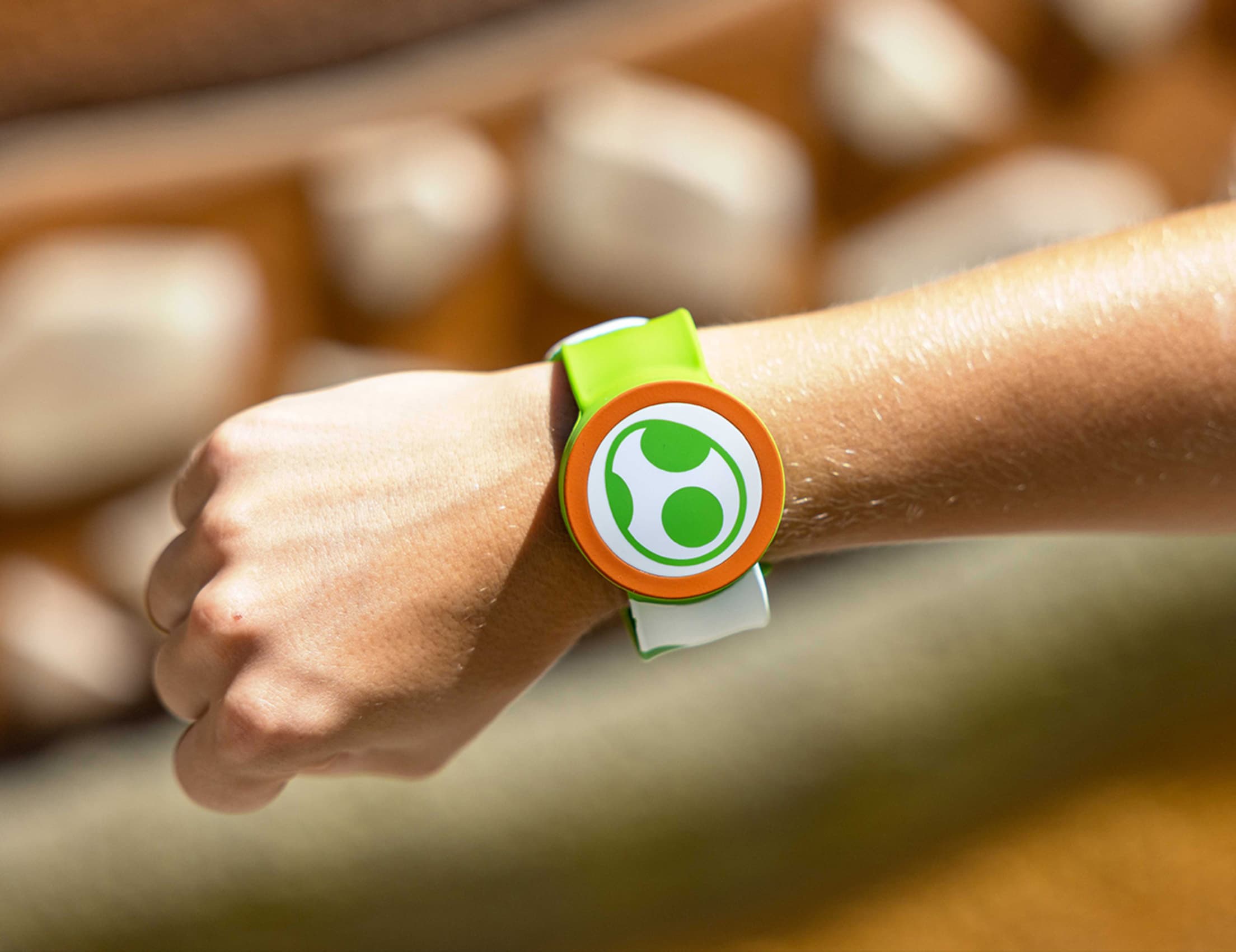 a person's wrist with a green and orange 'power up' band on it, for activating extras at Universal Studios Hollywood