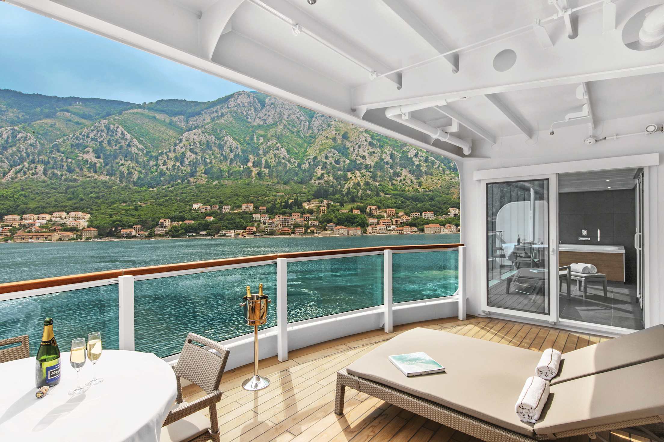 A table with two glasses of champagne on a balcony aboard the Seabourn Ovation cruise ship.