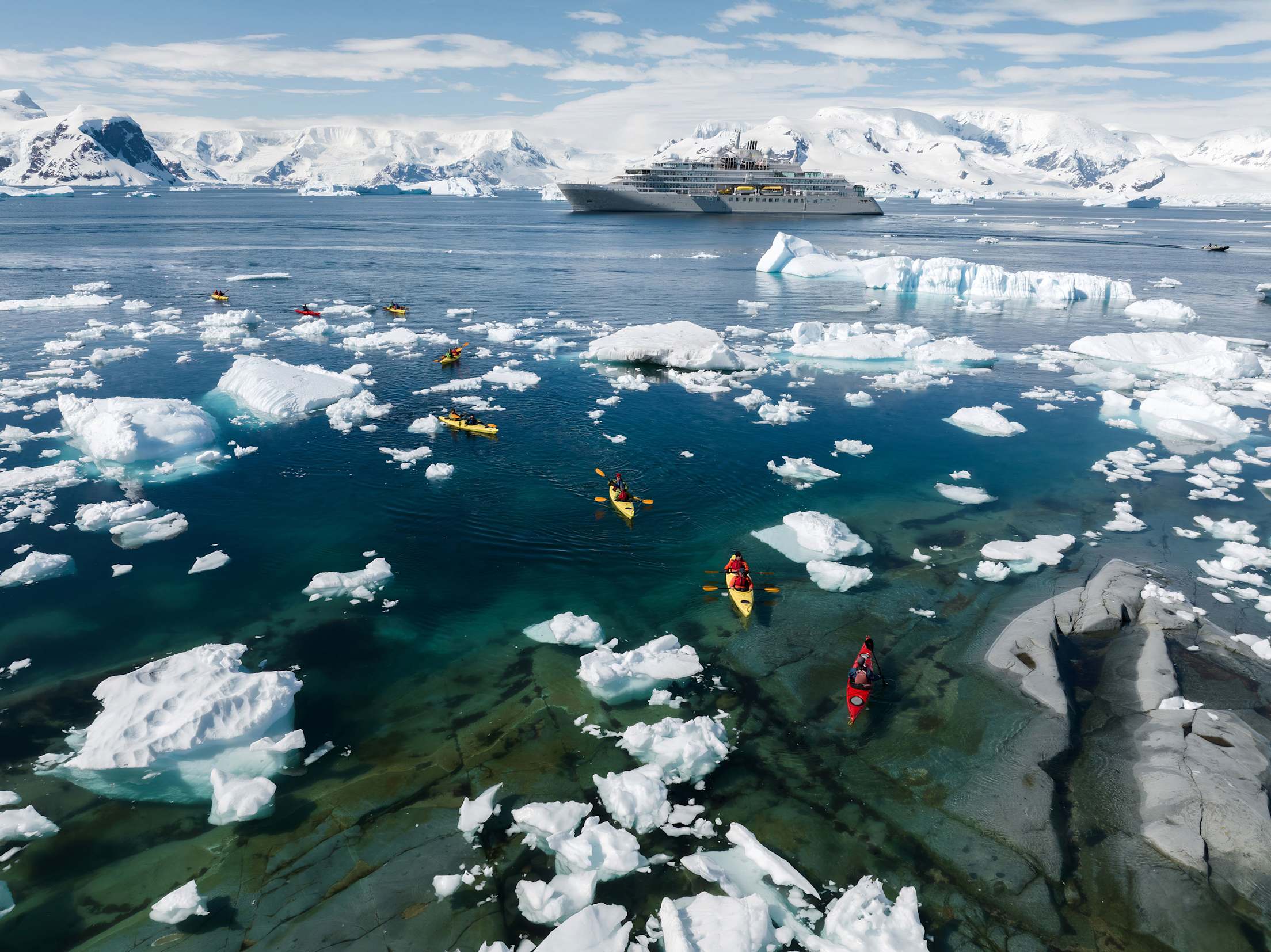 Overhead photo of kayakers paddling around icy waters of Neko Harbour, Antarctica.