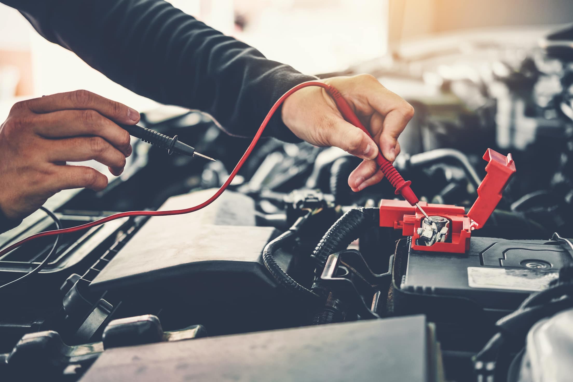 a person works on the engine of a car