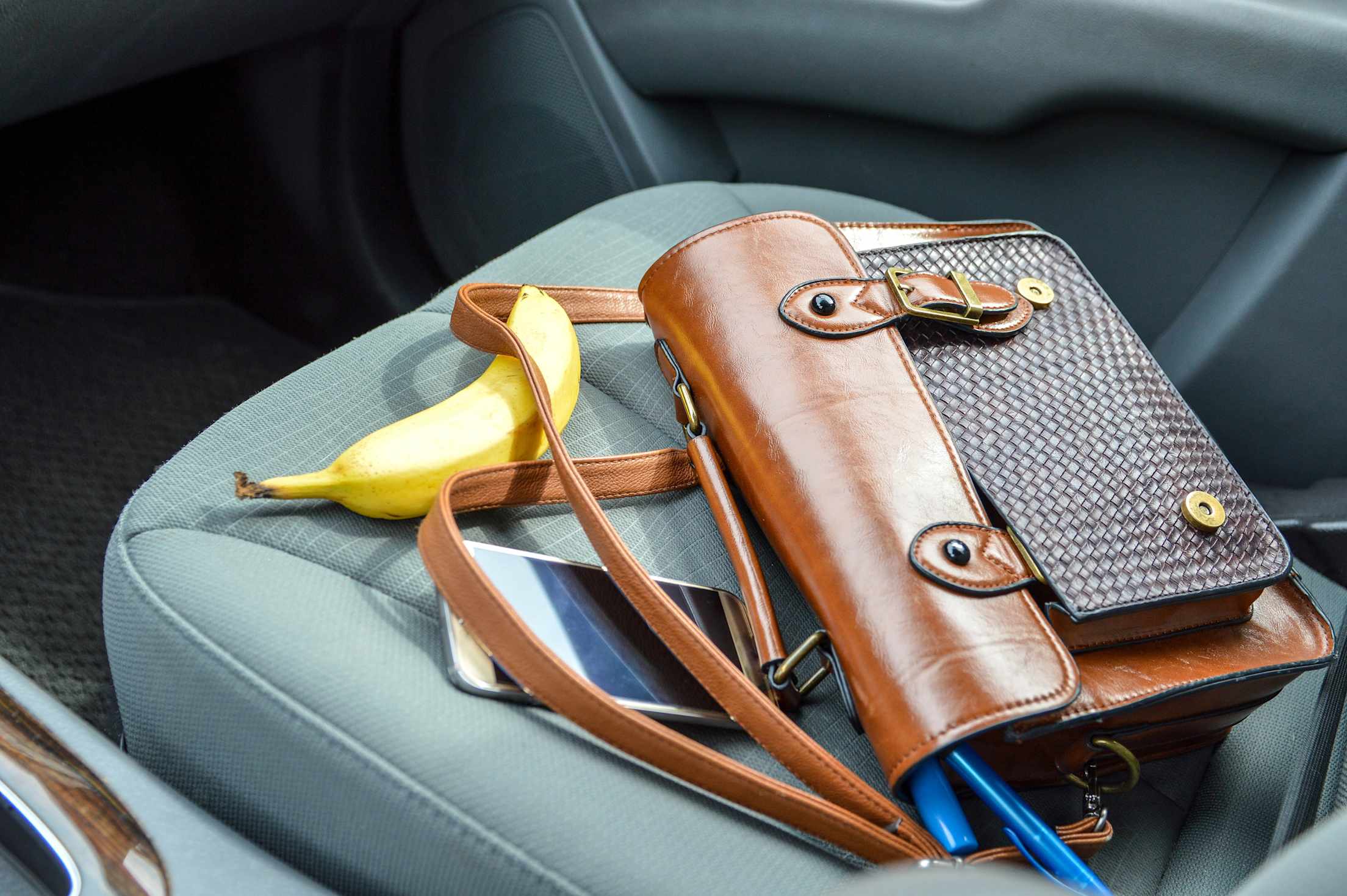 a purse and a banana on a car seat