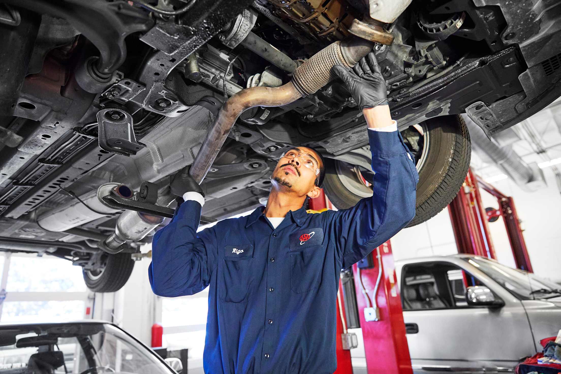 A AAA-approved auto mechanic works on a catalytic converter.
