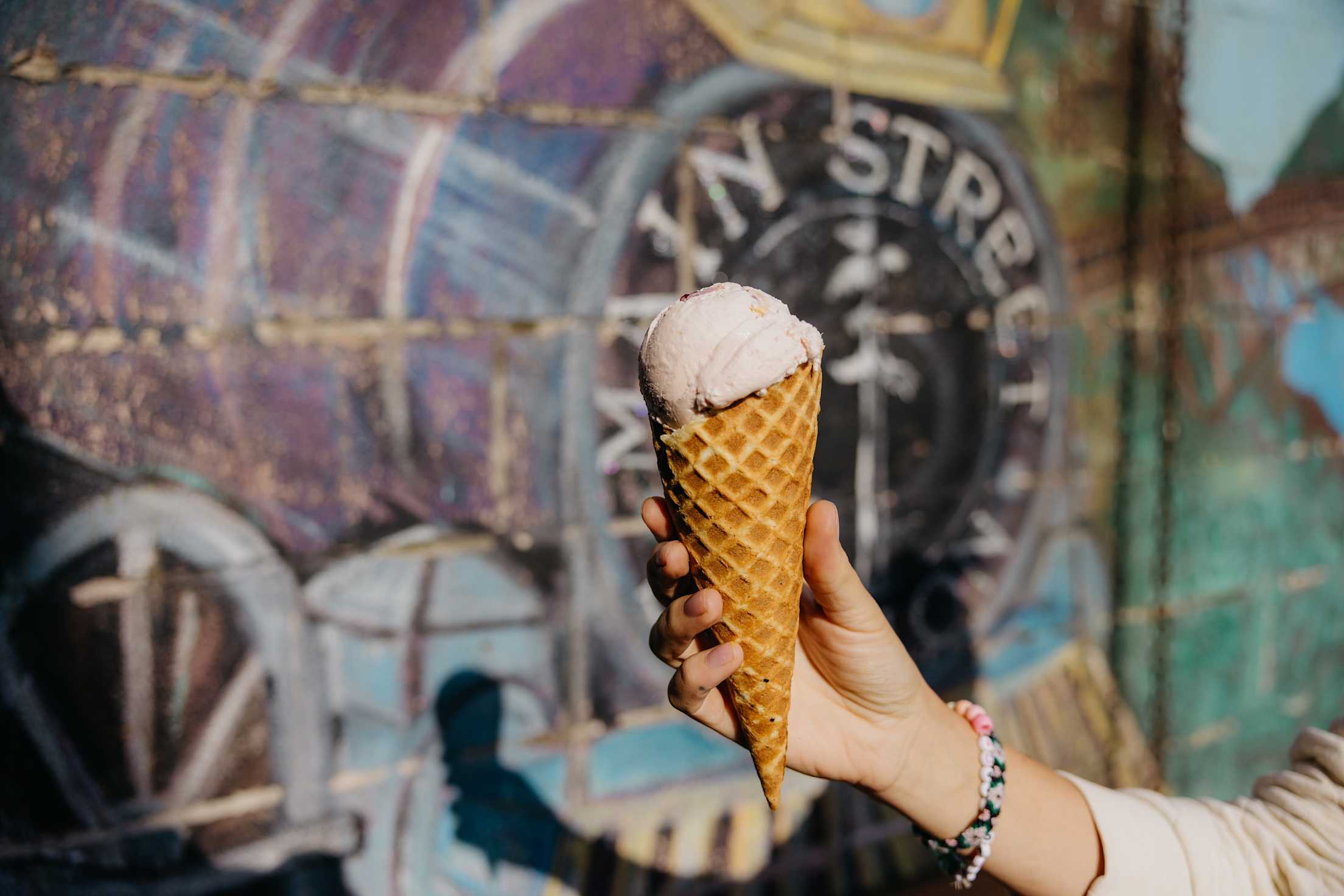 a hand holding a large ice cream cone