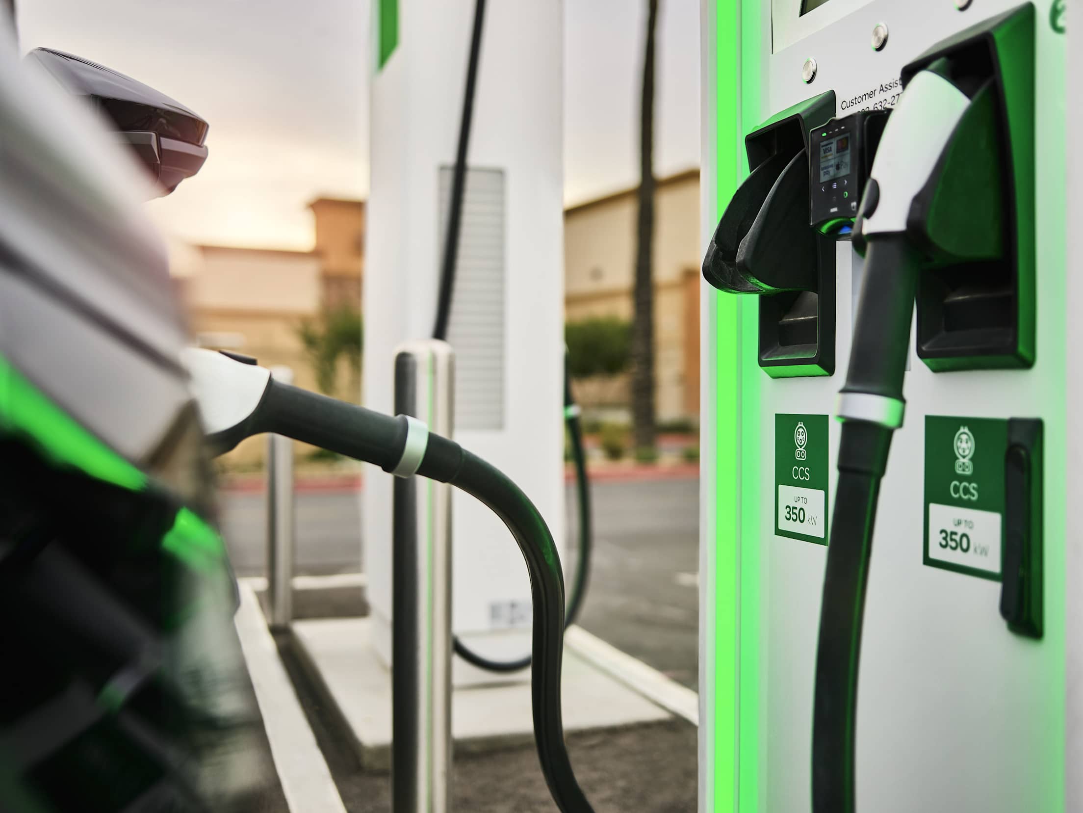 two electric vehicle chargers lit up in green