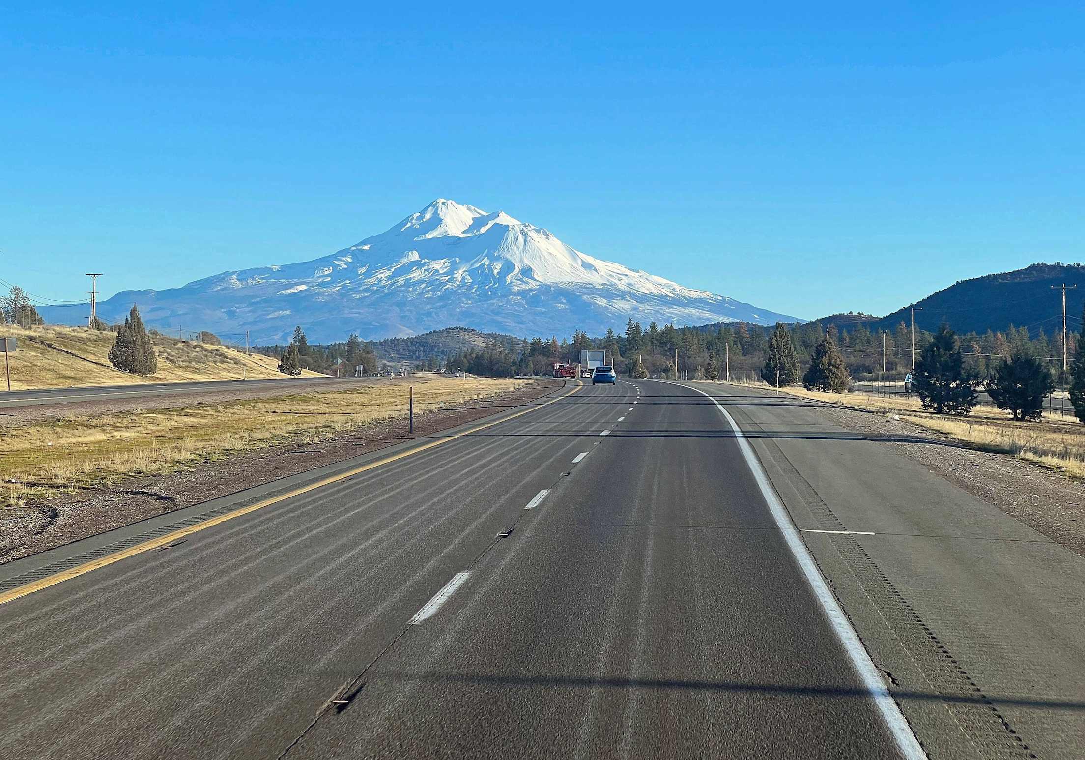 a snow-capped mountain is seen from a highway