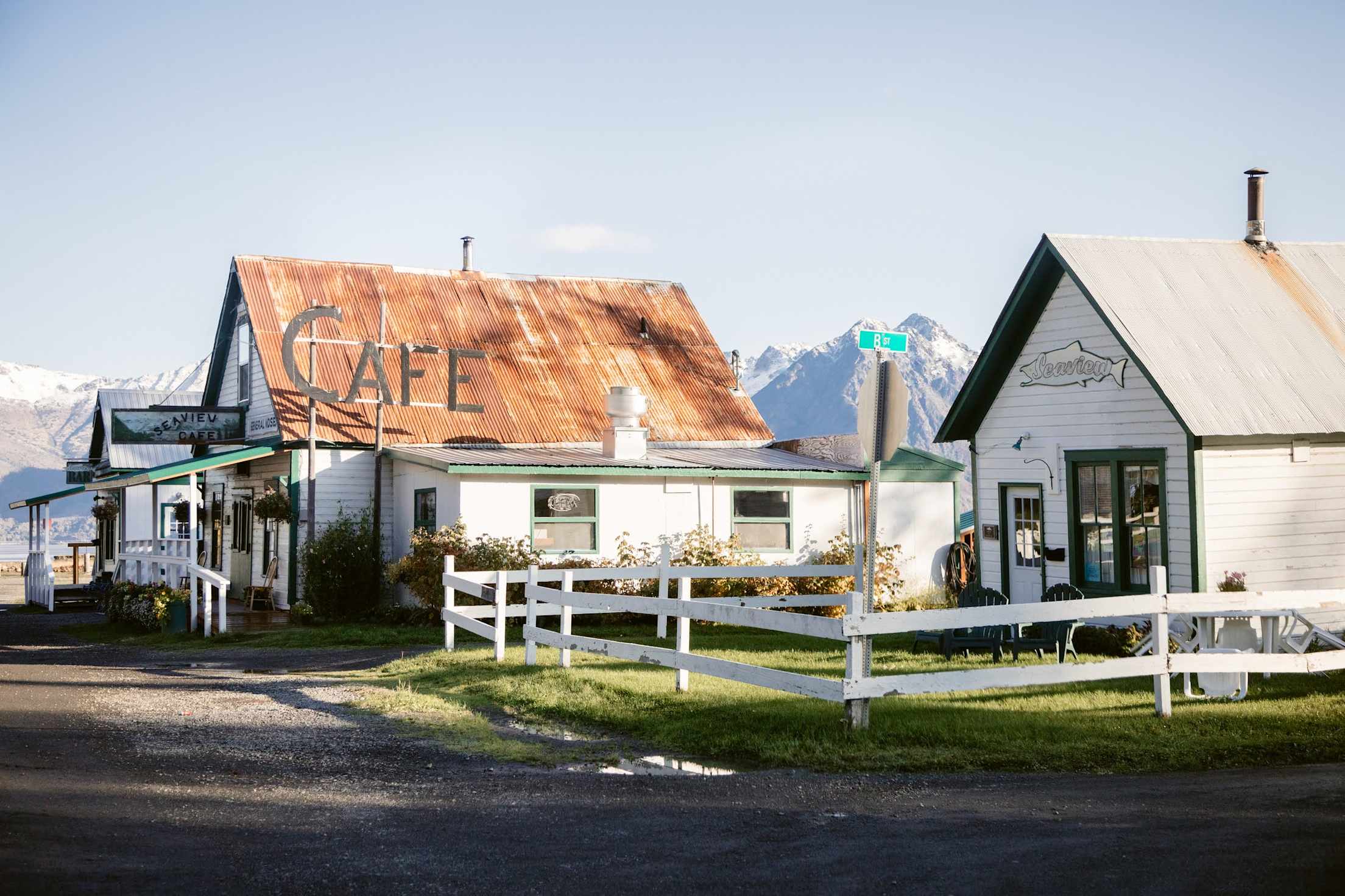 a quaint town with mountains in the background, the word "cafe" is visible
