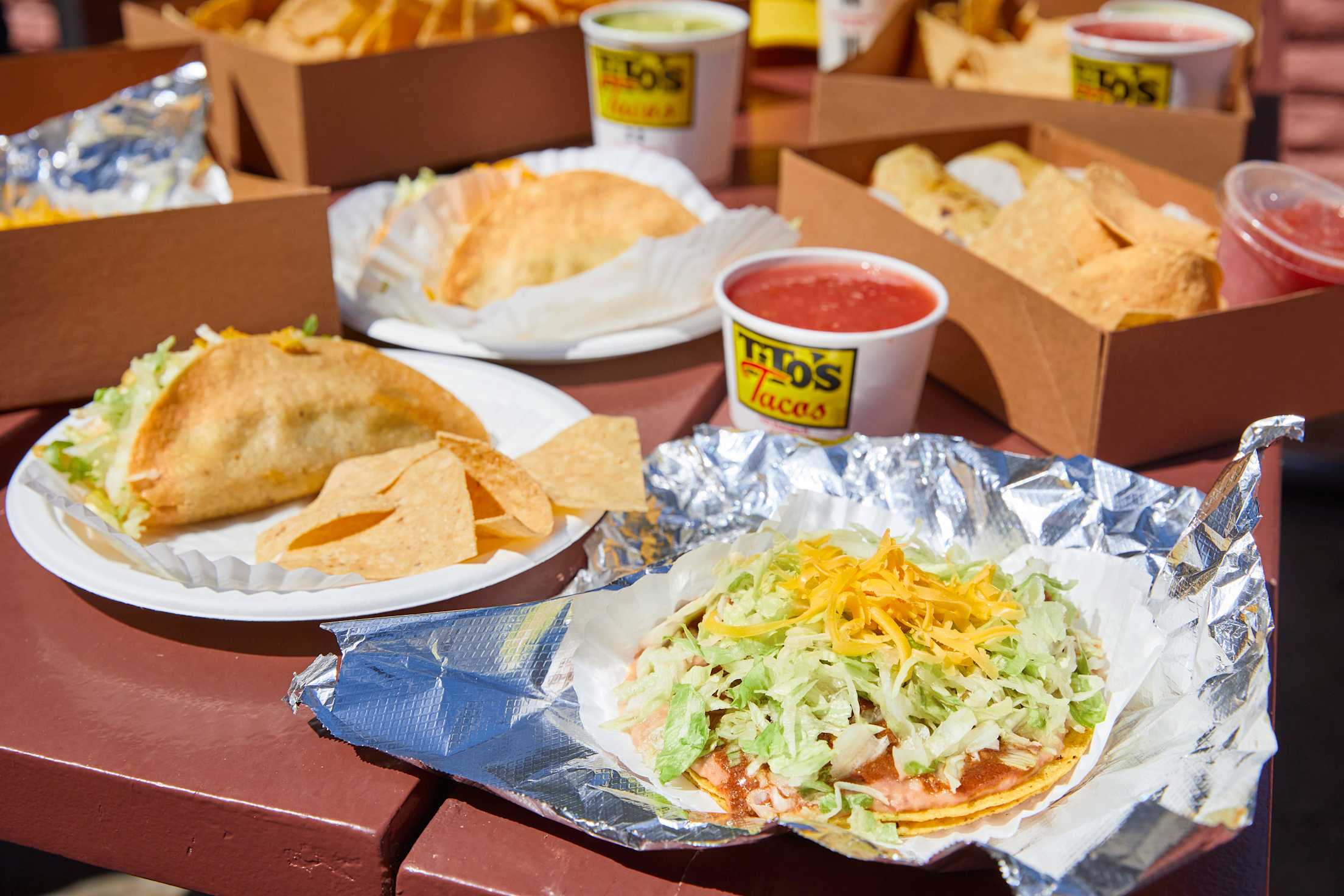 A tostada, crispy taco, tortilla chips and cup of salsa. 