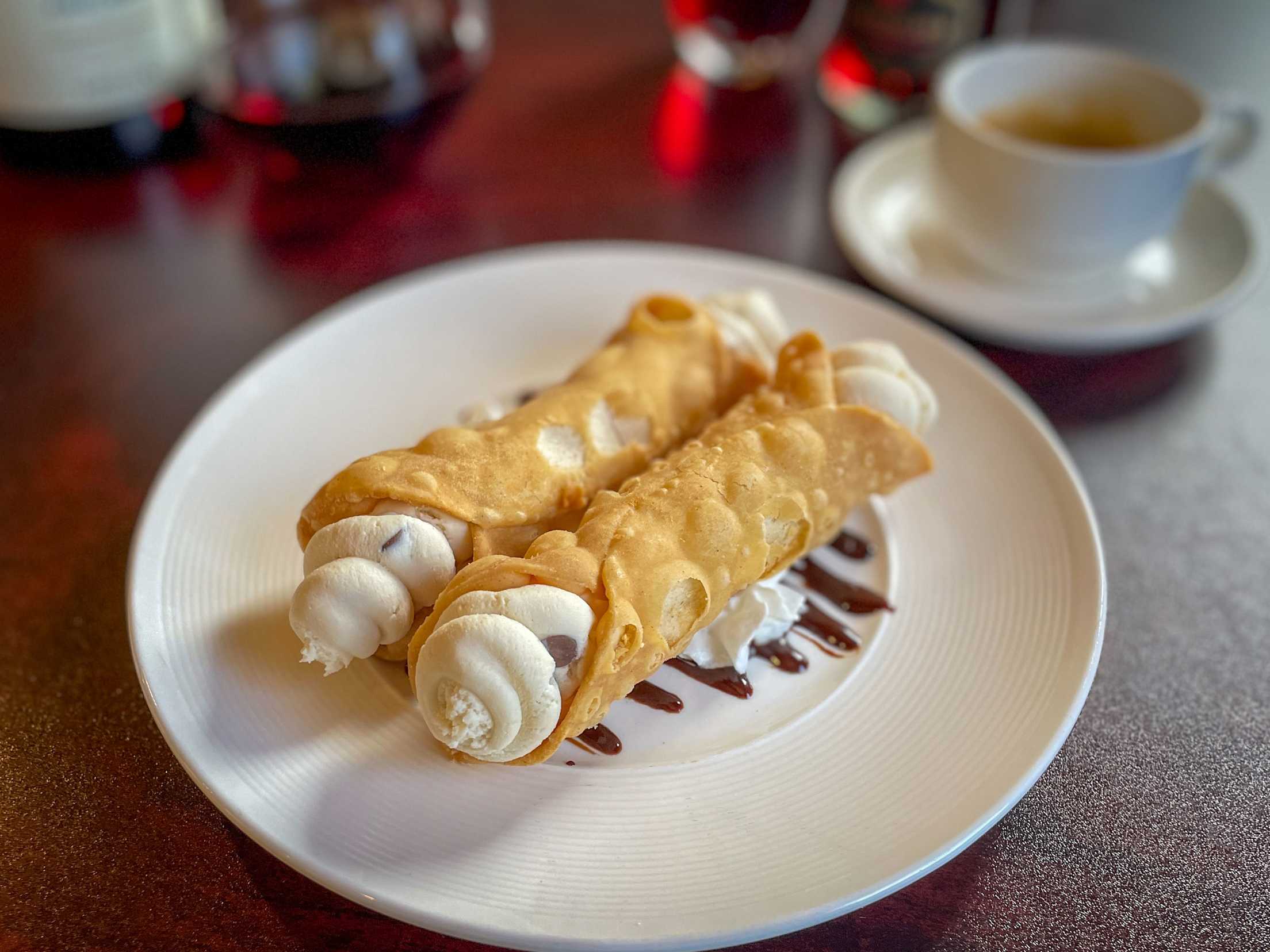 Ricotta cheese–filled cannoli sit on a plate.