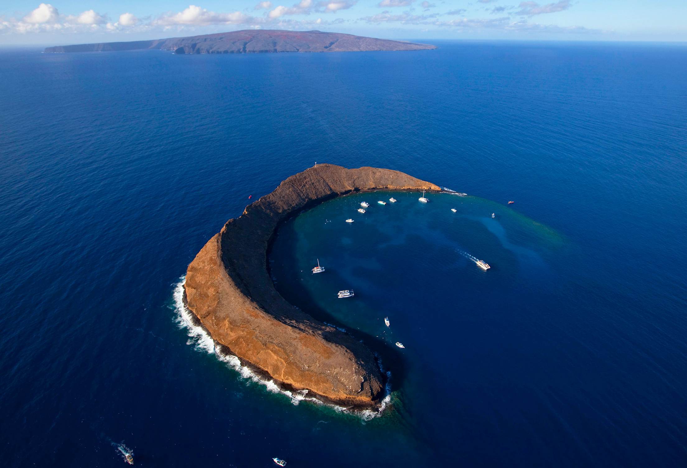 Molokini, a cresent-shaped islet, with Maui in the distance