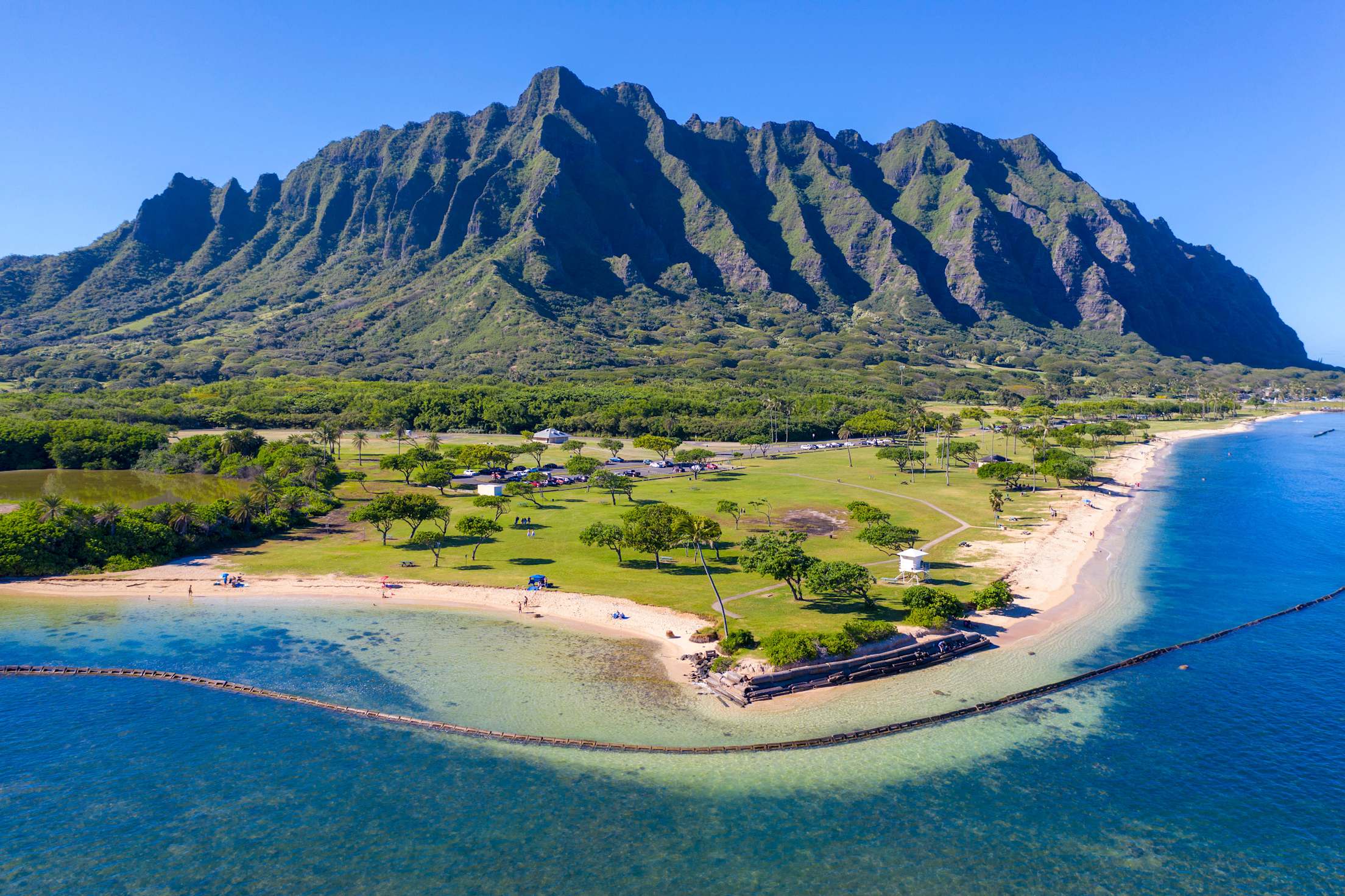 mountains rise above a beach-side park