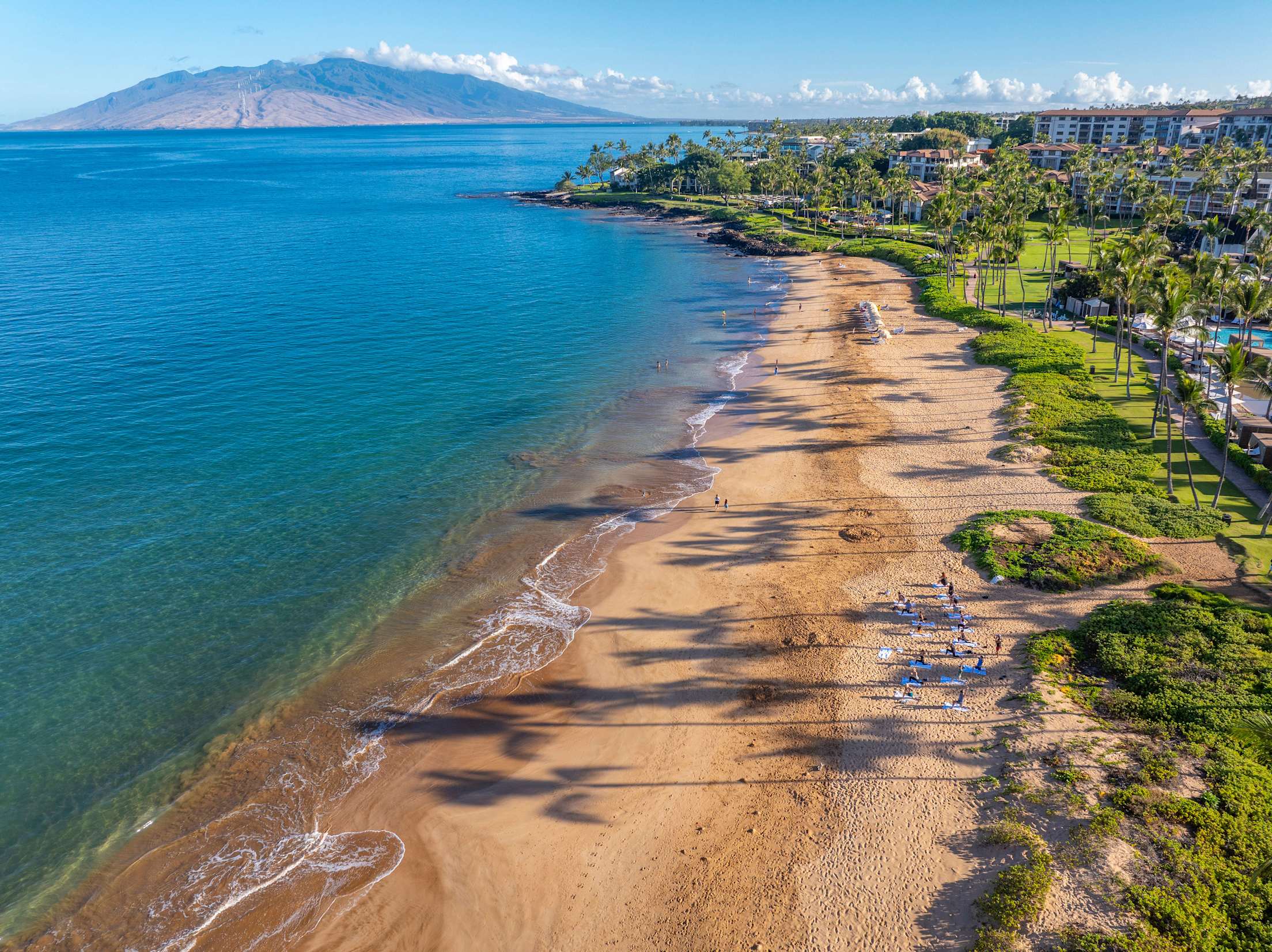 A sandy beach with views of Molokini Crater in the background