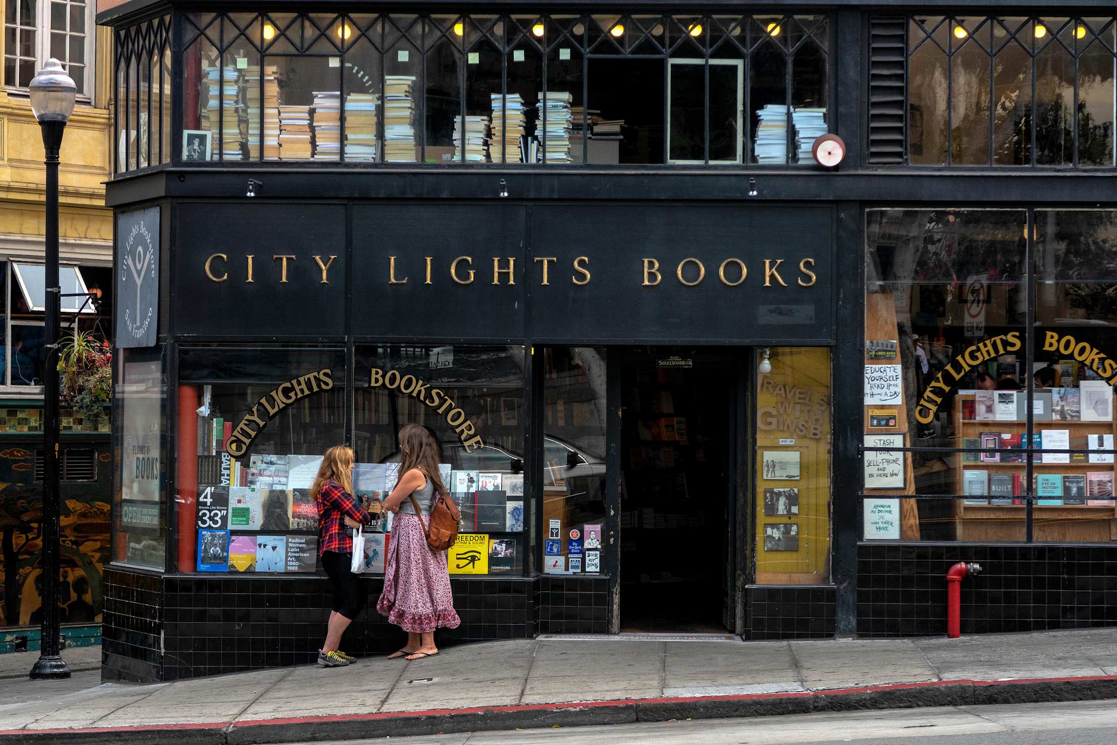 Women standing in front of City Lights Bookstore in San Francisco.