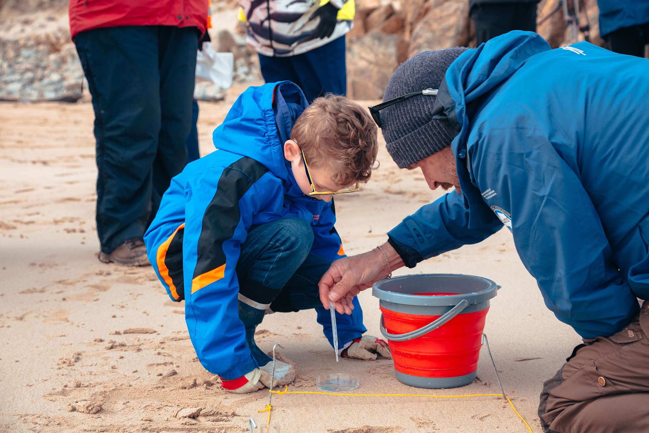 A child and a guide from HX Expeditions prepare a citizen science sample on a cruise excursion.