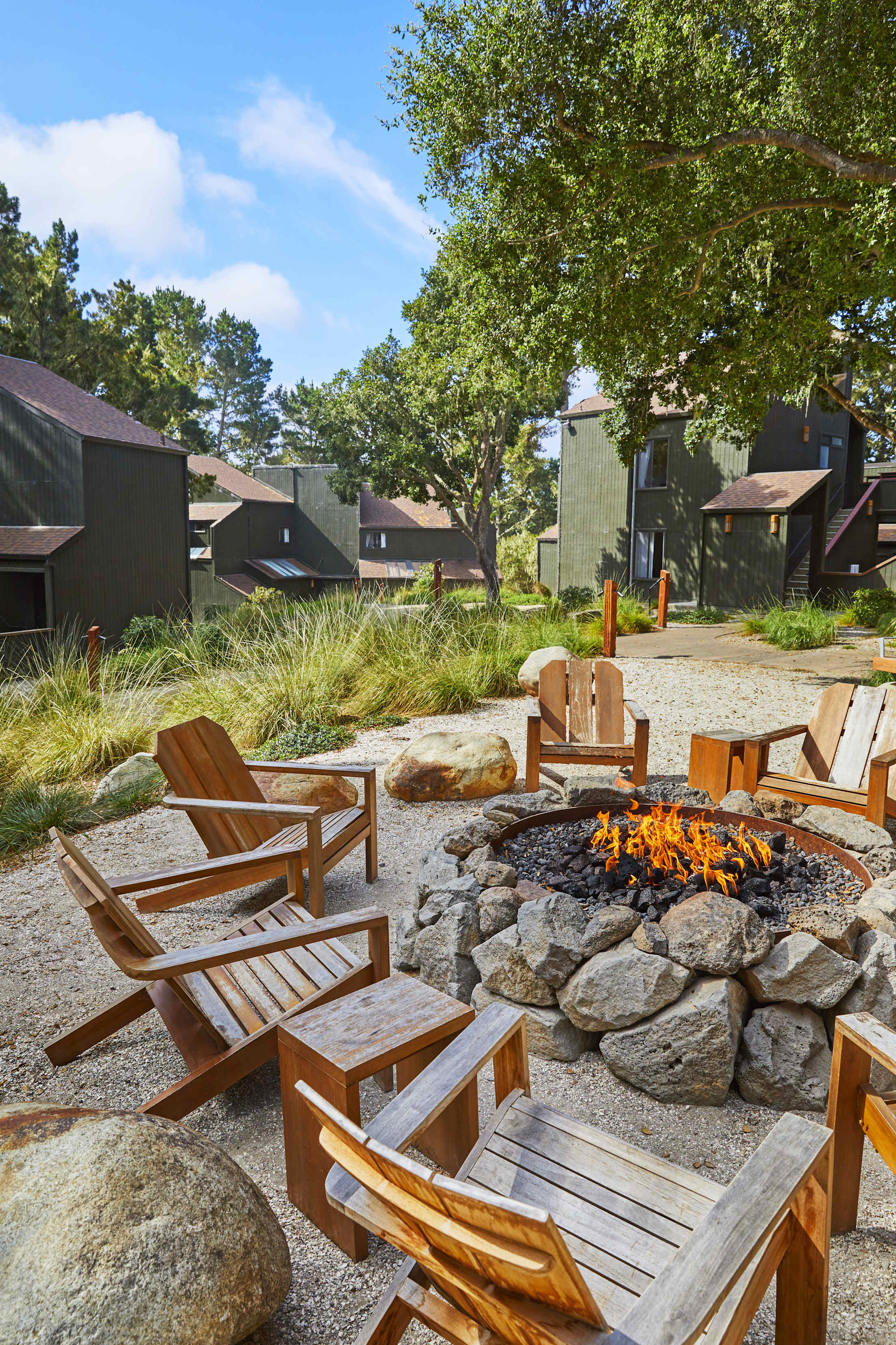 wooden lounge chairs around a fire pit