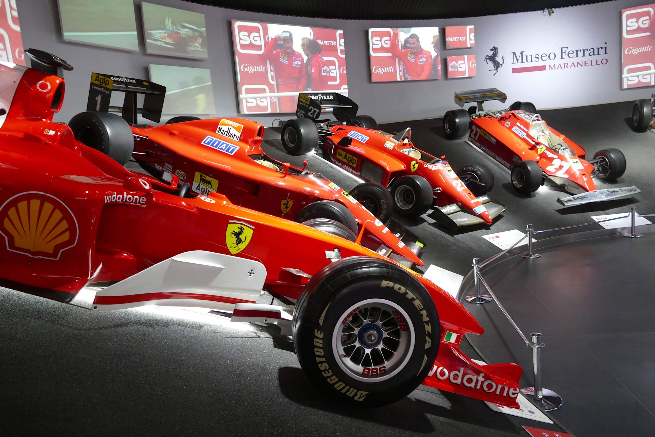 Red Formula 1 race cars with the Ferrari logo