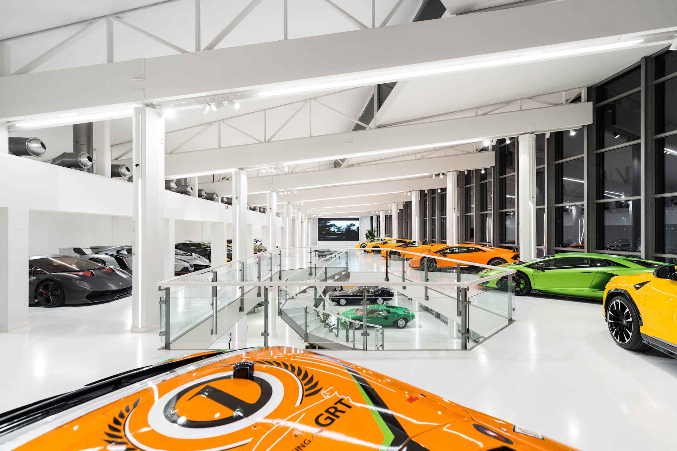 Lamborghinis lined up in a modern white showroom