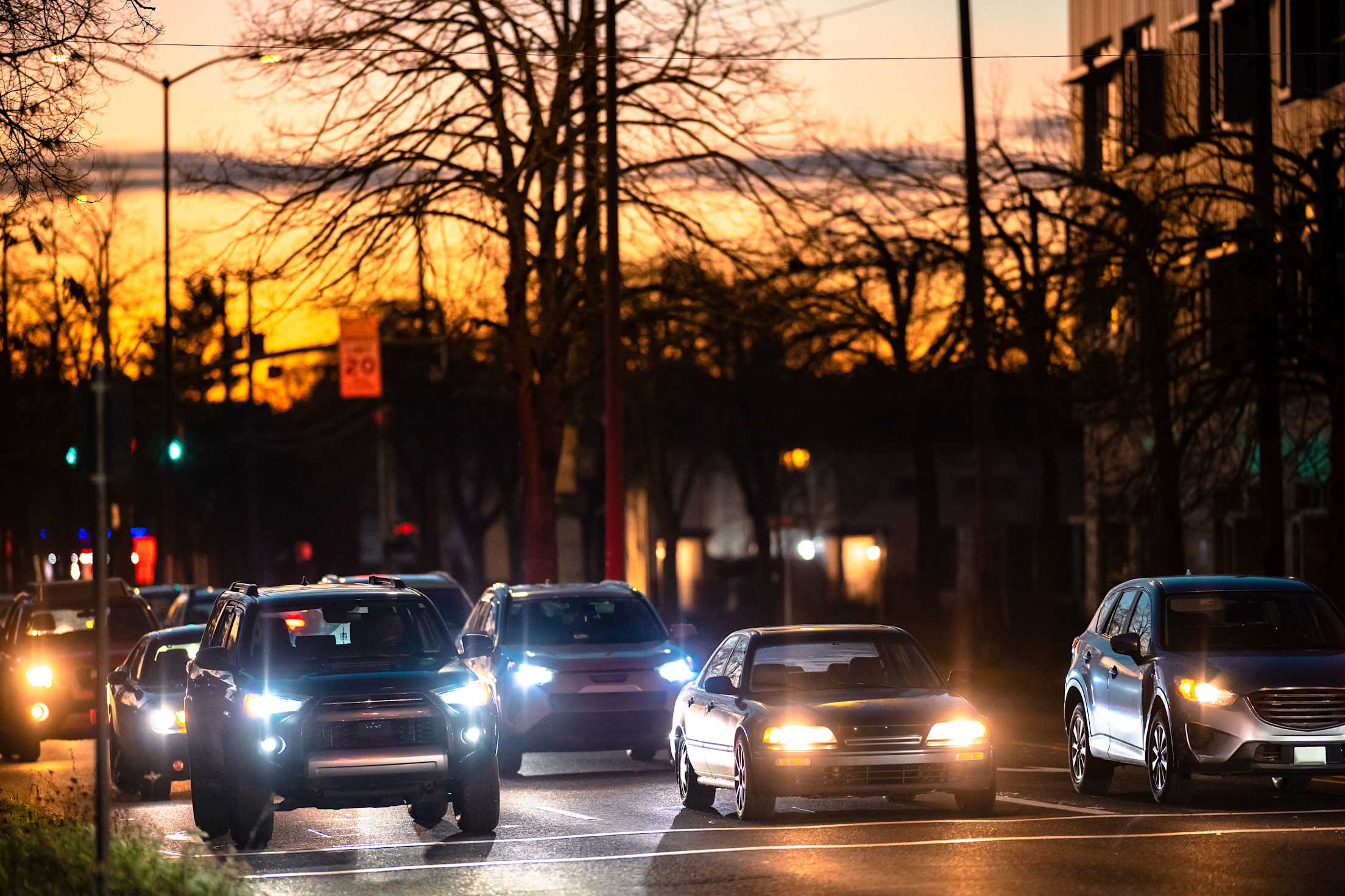 Cars driving through a city at sunset