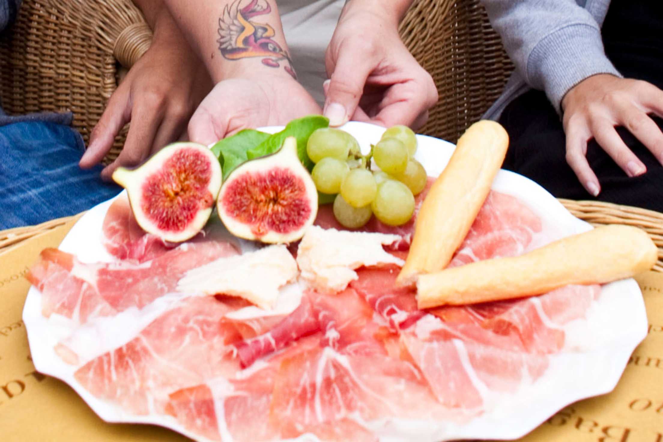 prosciutto platter with fruit on a table in Italy.