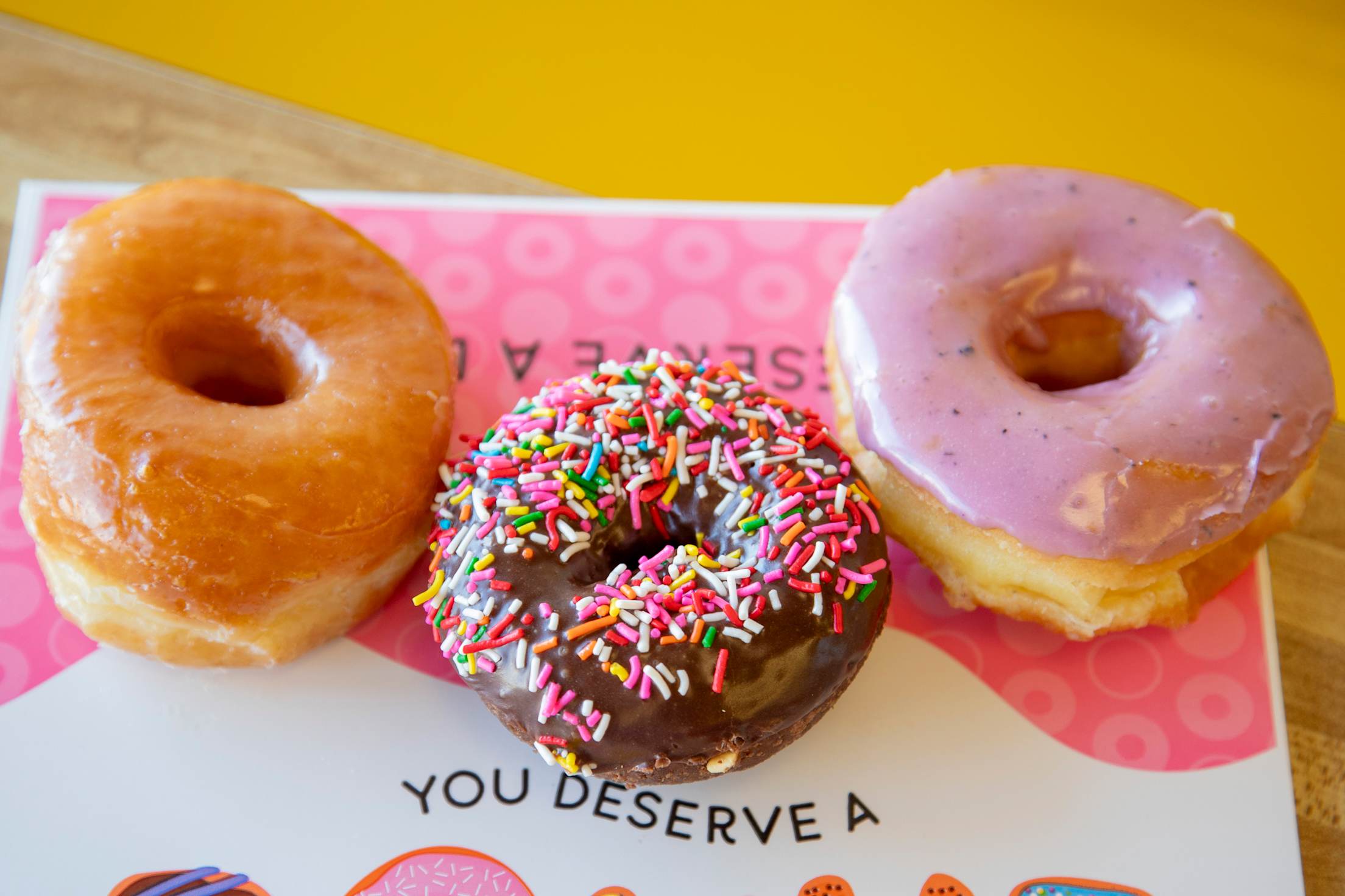 Three donuts, including a chocolate sprinkle, on a table at Fresh Donuts & Deli in Salt Lake City, Utah.