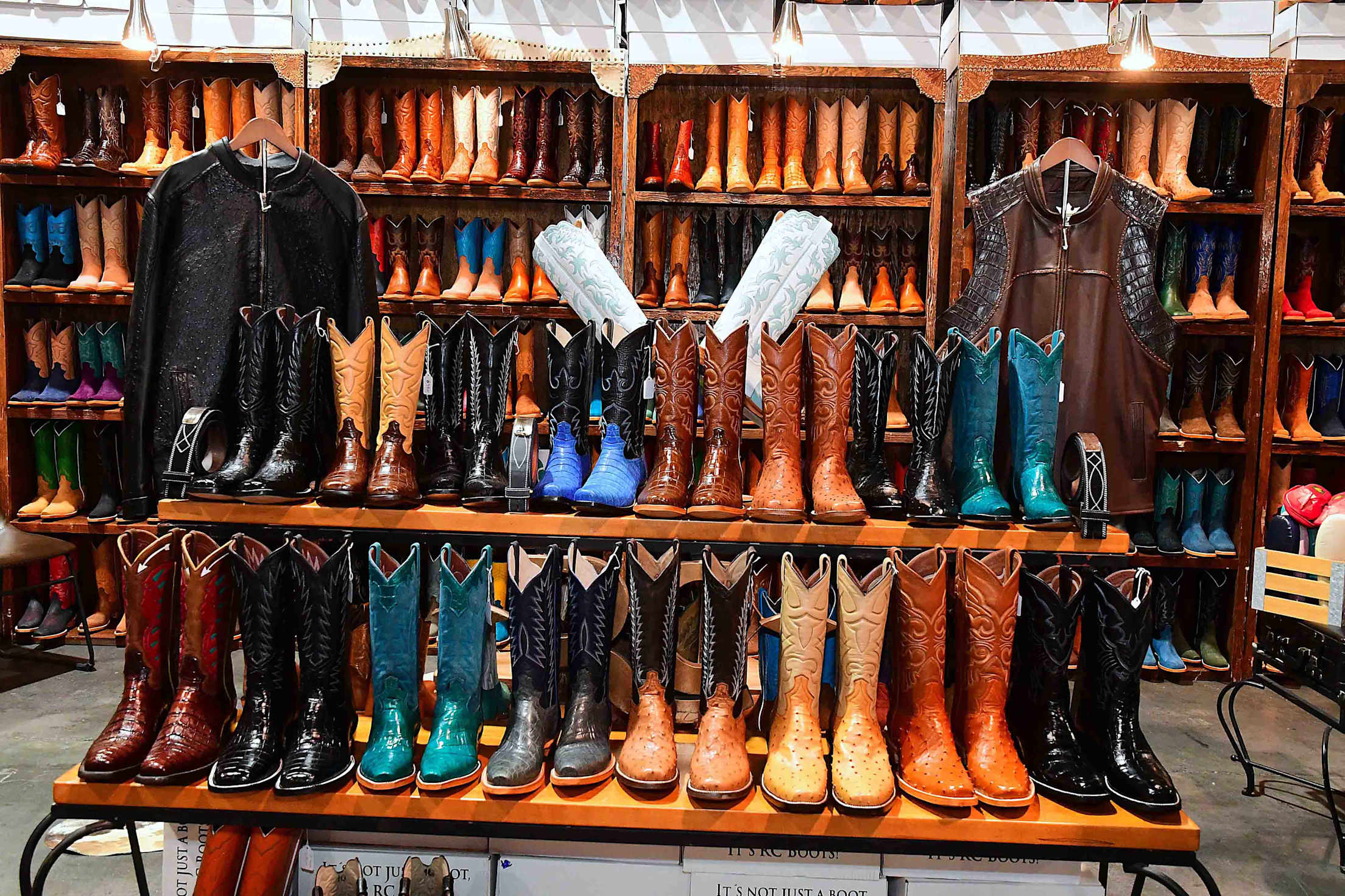 rows of colorful cowboy boots on a shelf