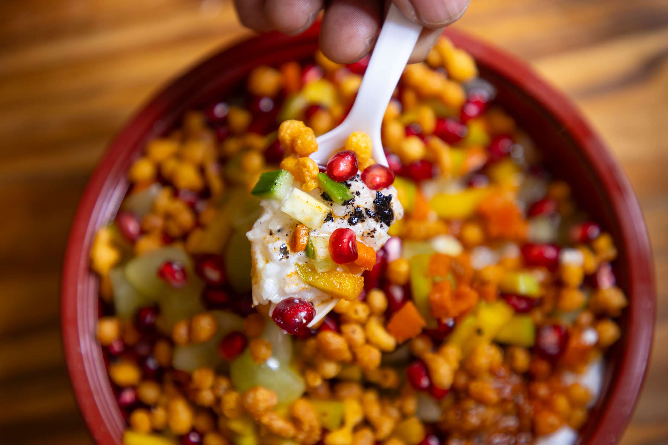 a bowl with pomegranate seeds, grains, and other ingredients