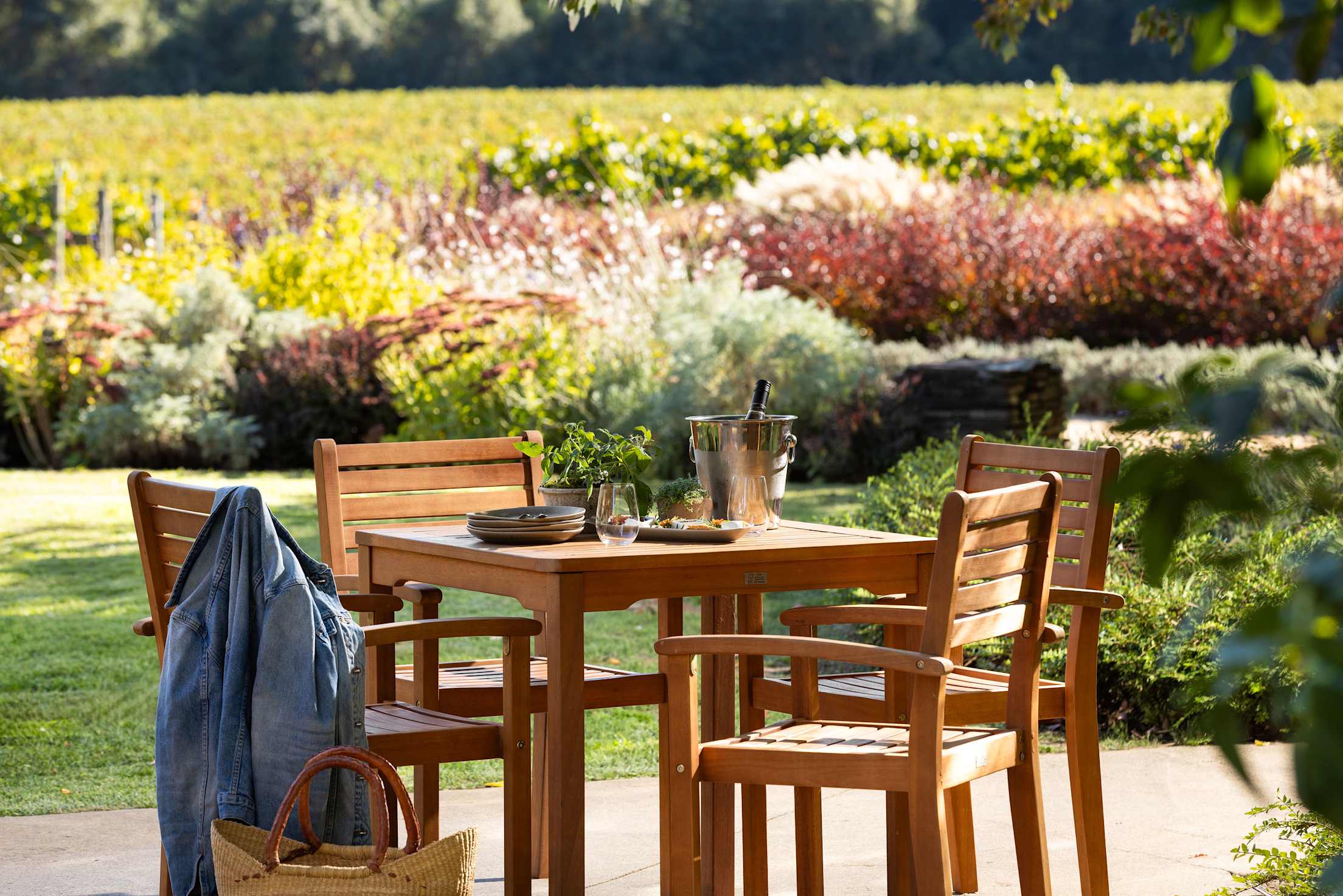 a wooden table set up for a wine tasting in a picturesque vineyard
