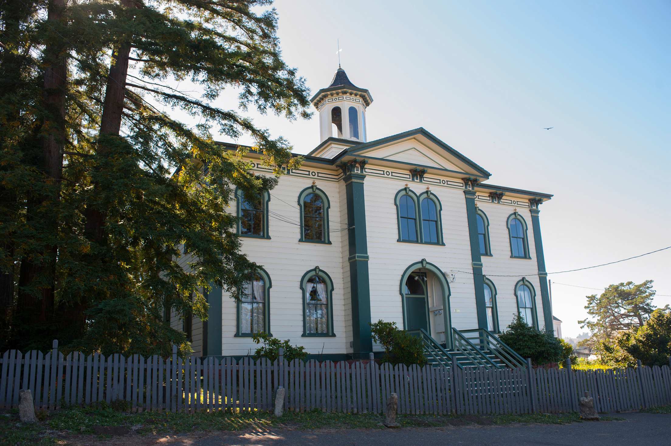 the front of an old white and green schoolhouse