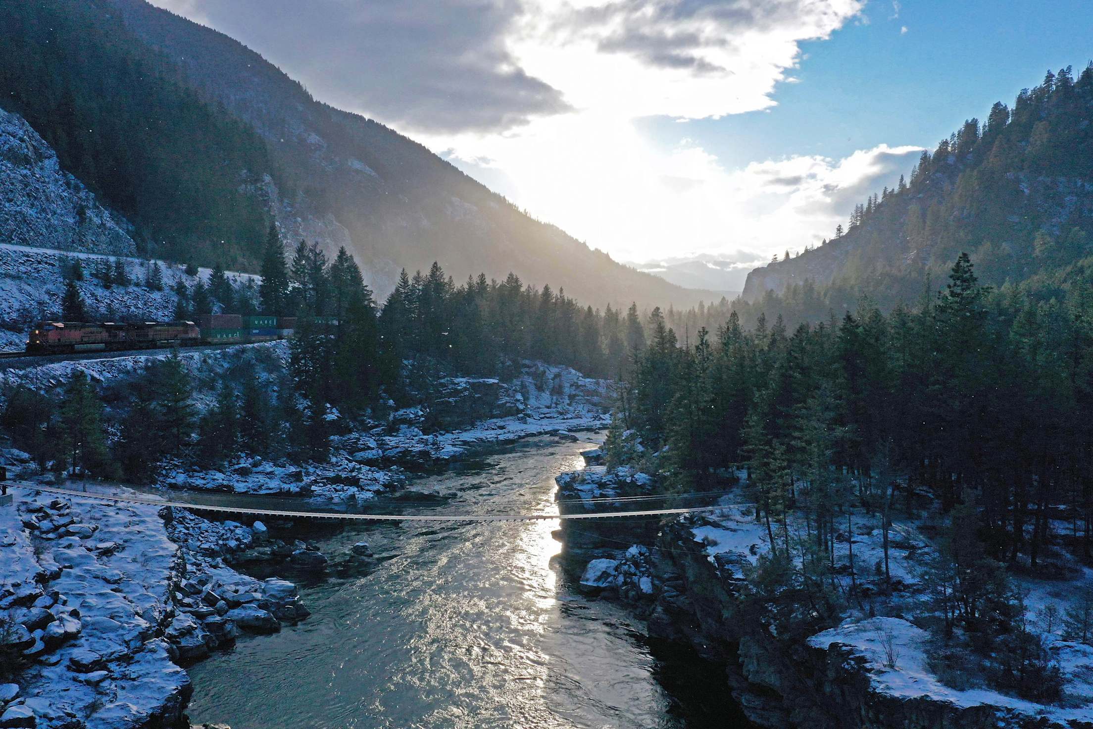 a river, mountains and pine trees