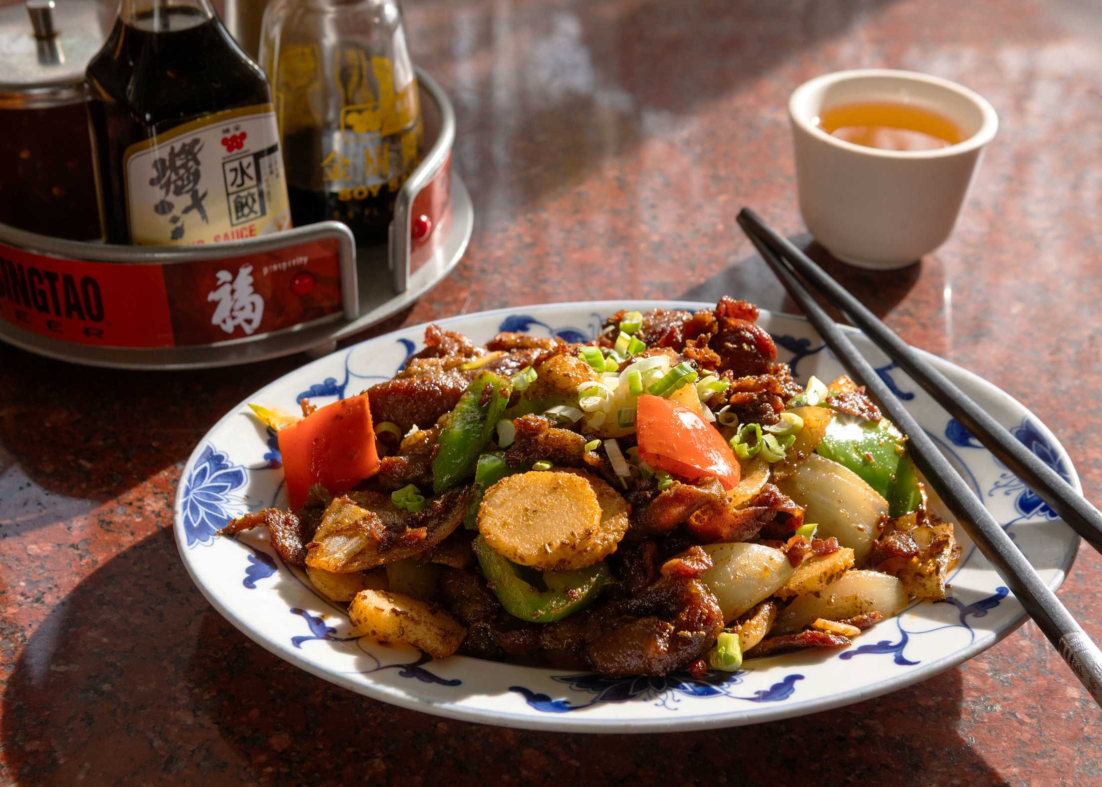 Lamb stir-fry with scallion from Old Mandarin Islamic on a blue and white plate.