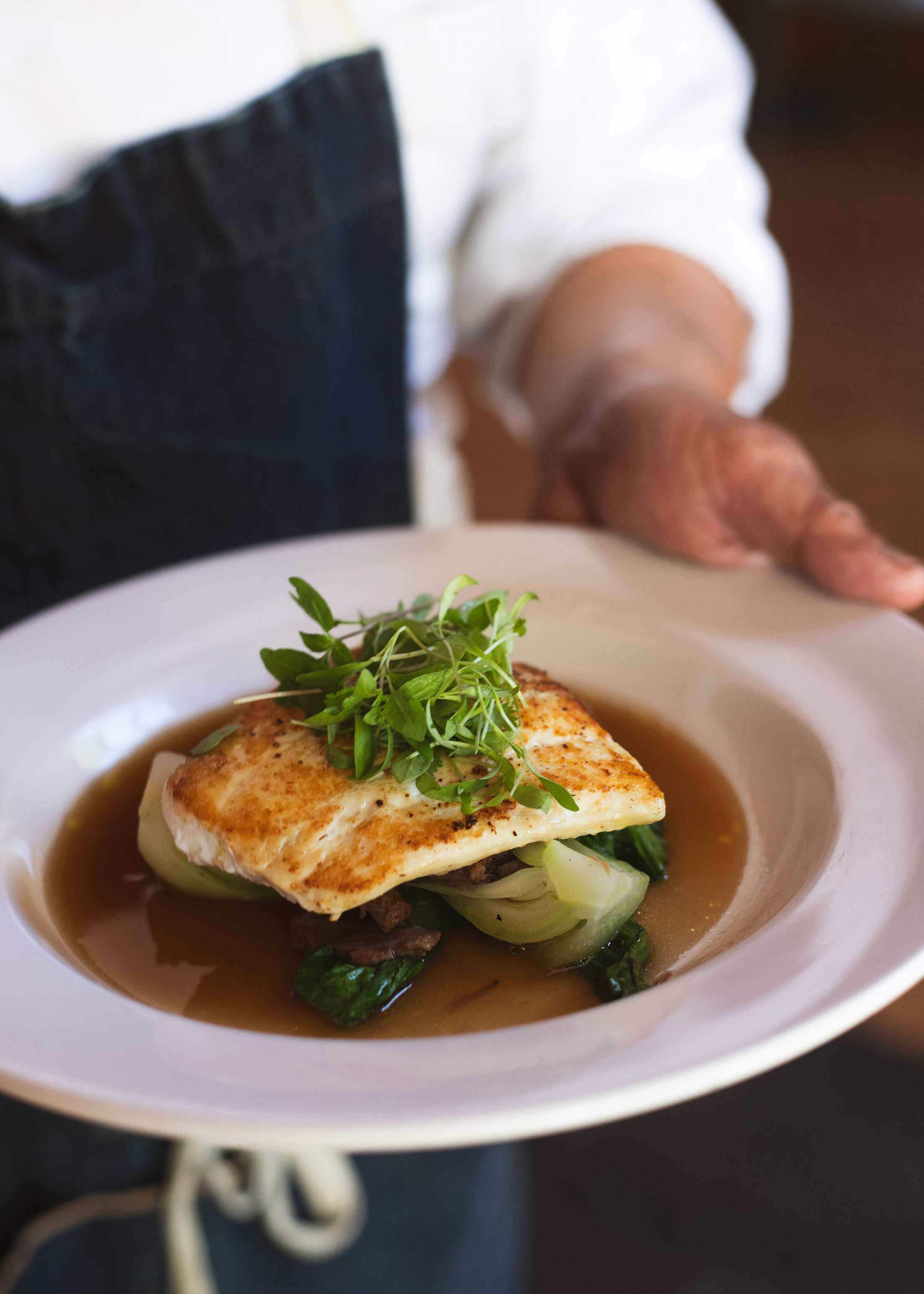 Seared market fish on a white plate at The Sur House at Ventana in Big Sur, California