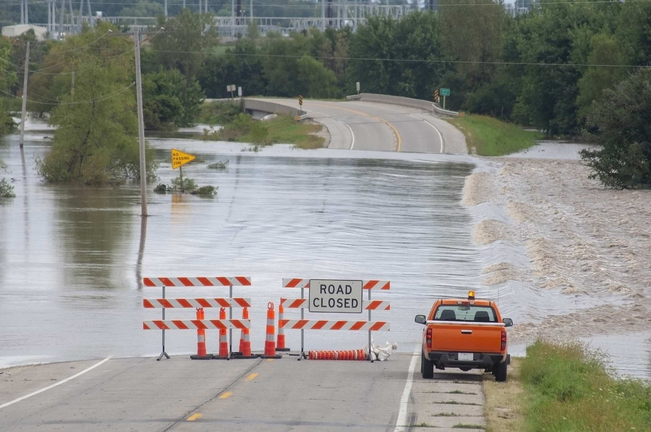 A road closed sign on a flooded road.