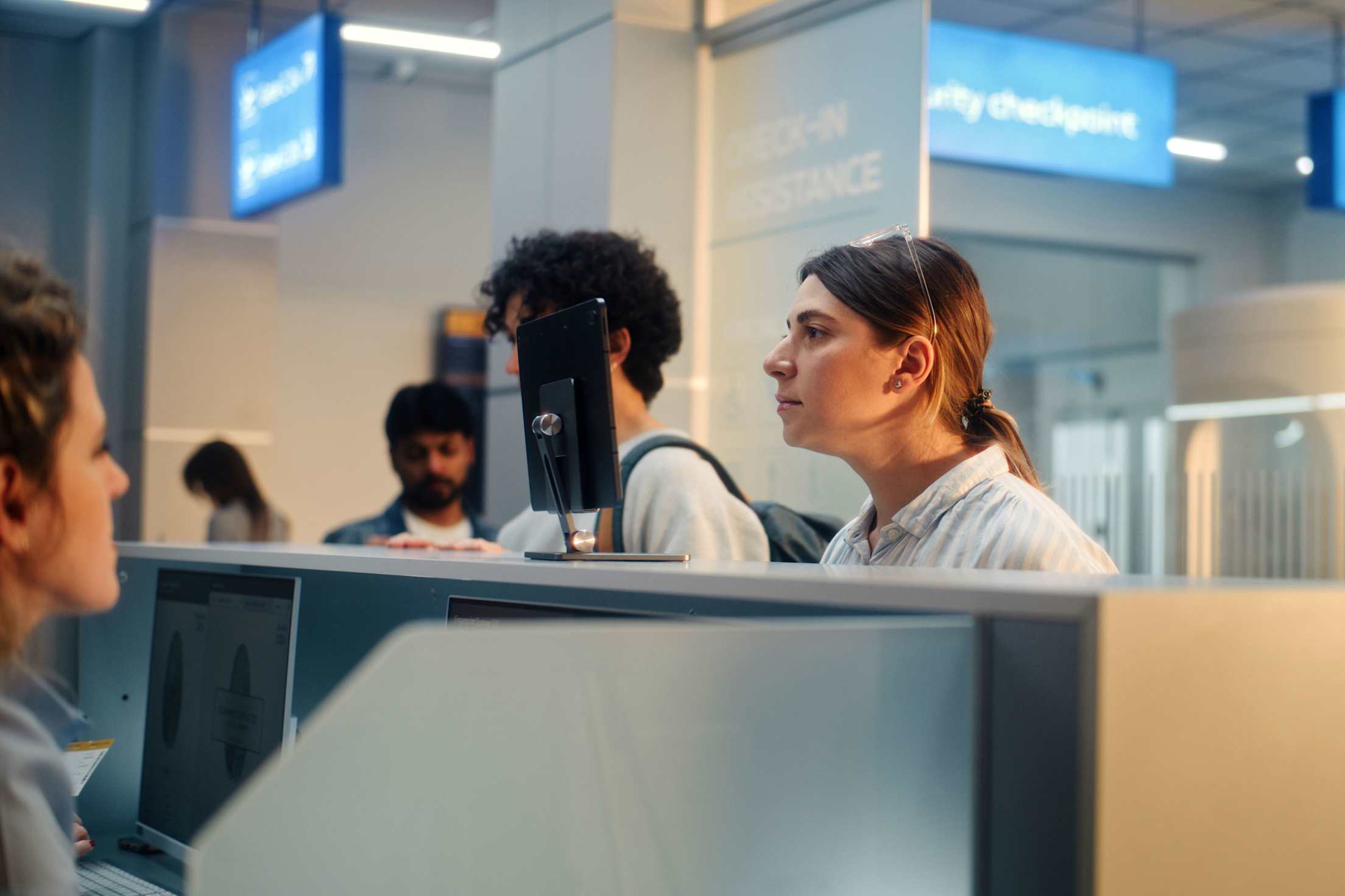A woman uses facial recognition technology at a security checkpoint in the airport.