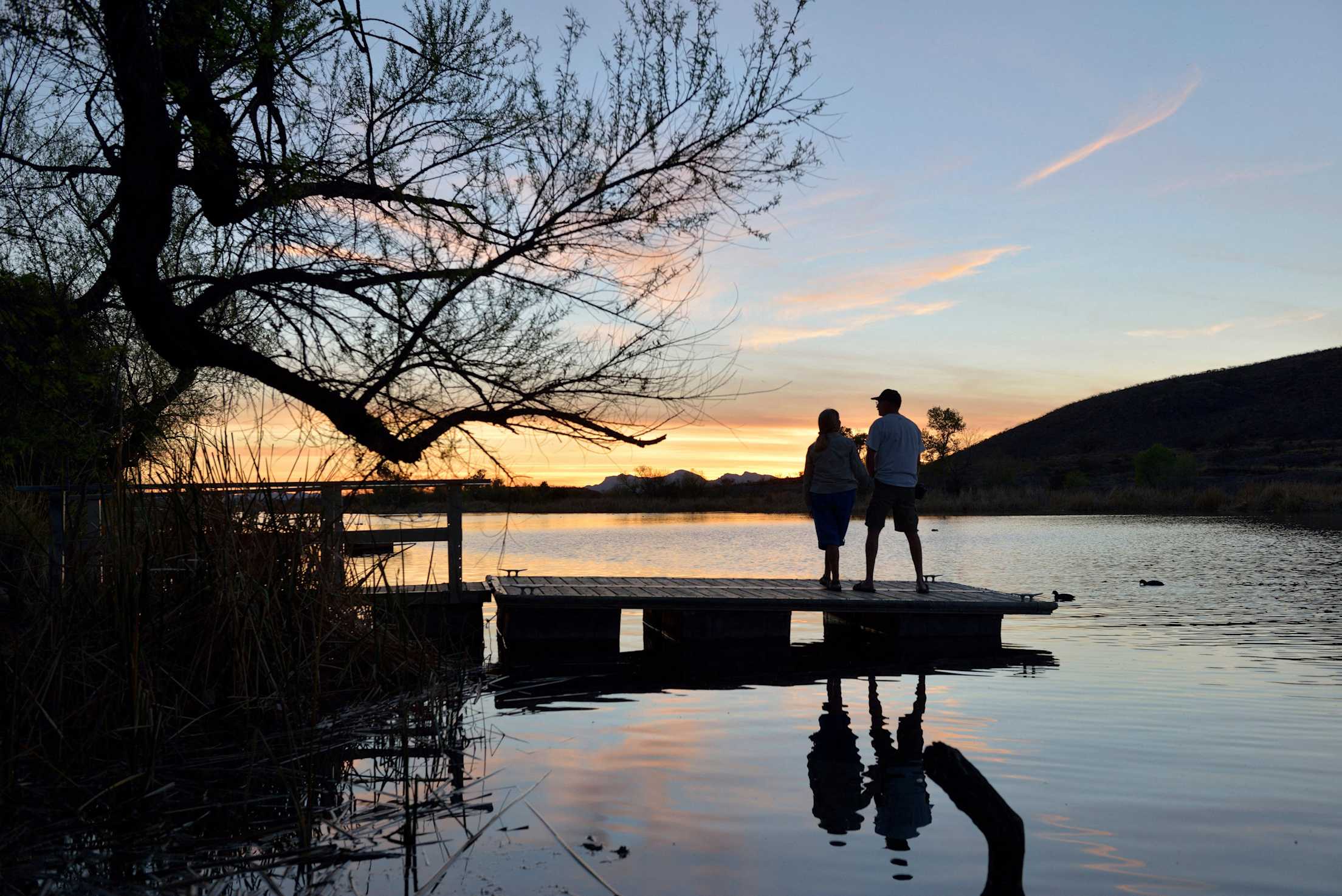 A couple stands on a dock at Patagonia Lake State Park in Arizona.