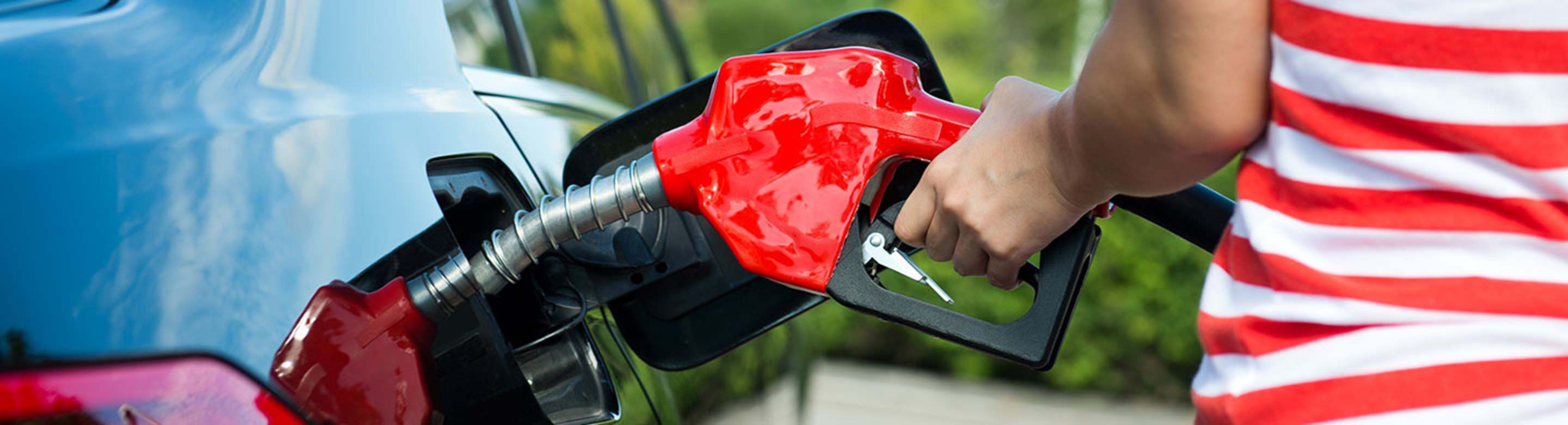 a AAA Member refuels her car at the gas pump
