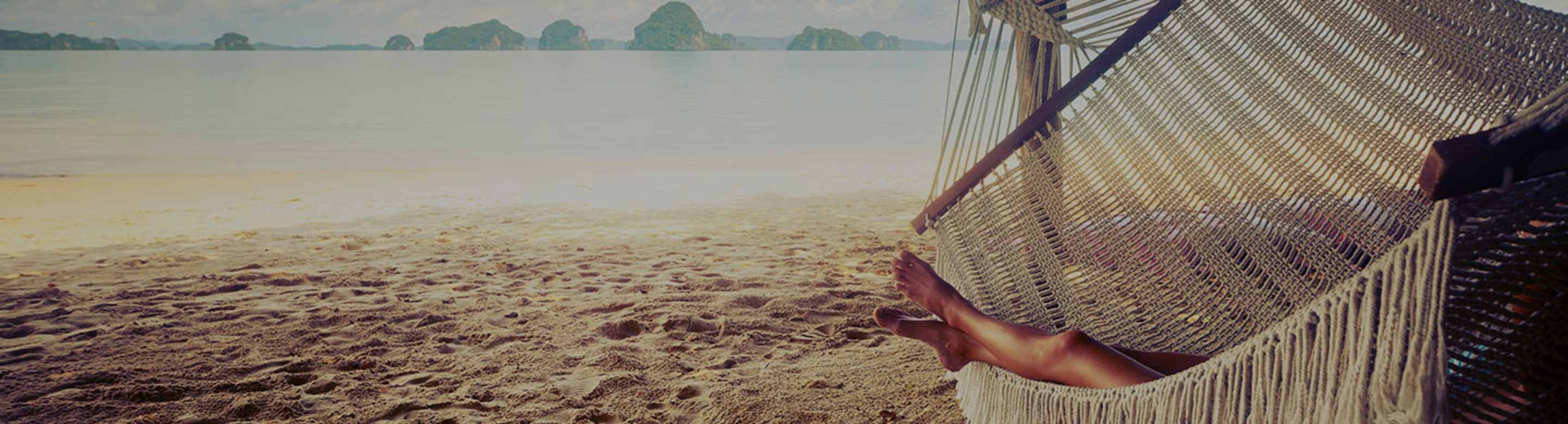 A AAA Member with auto renew membership relaxes in a hammock at the beach on vacation