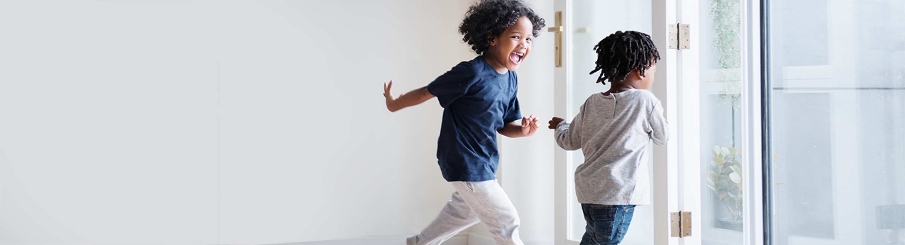 Two young sisters run through their new condo home insured by AAA.
