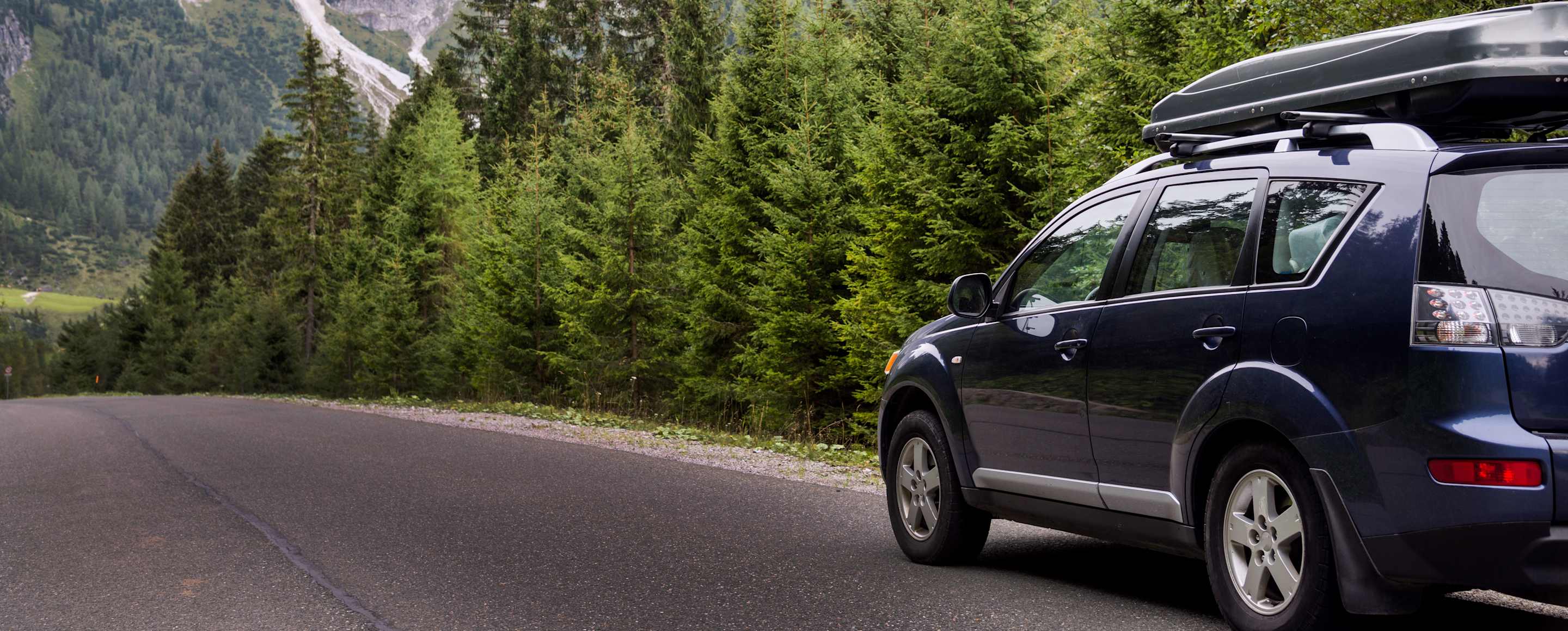 car protected by AAA auto insurance driving down a mountain road