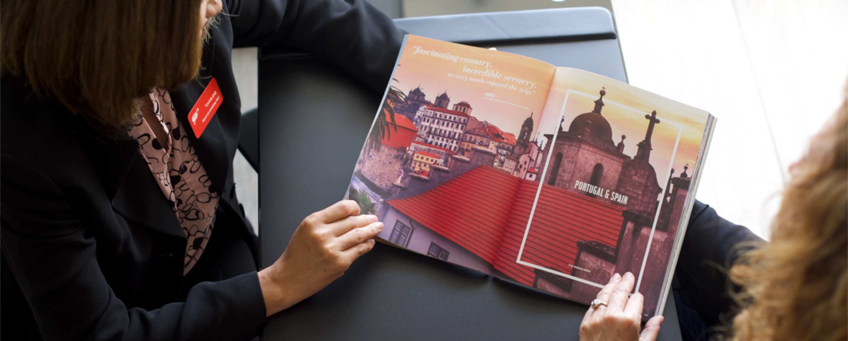 AAA travel agent showing a travel book to a client