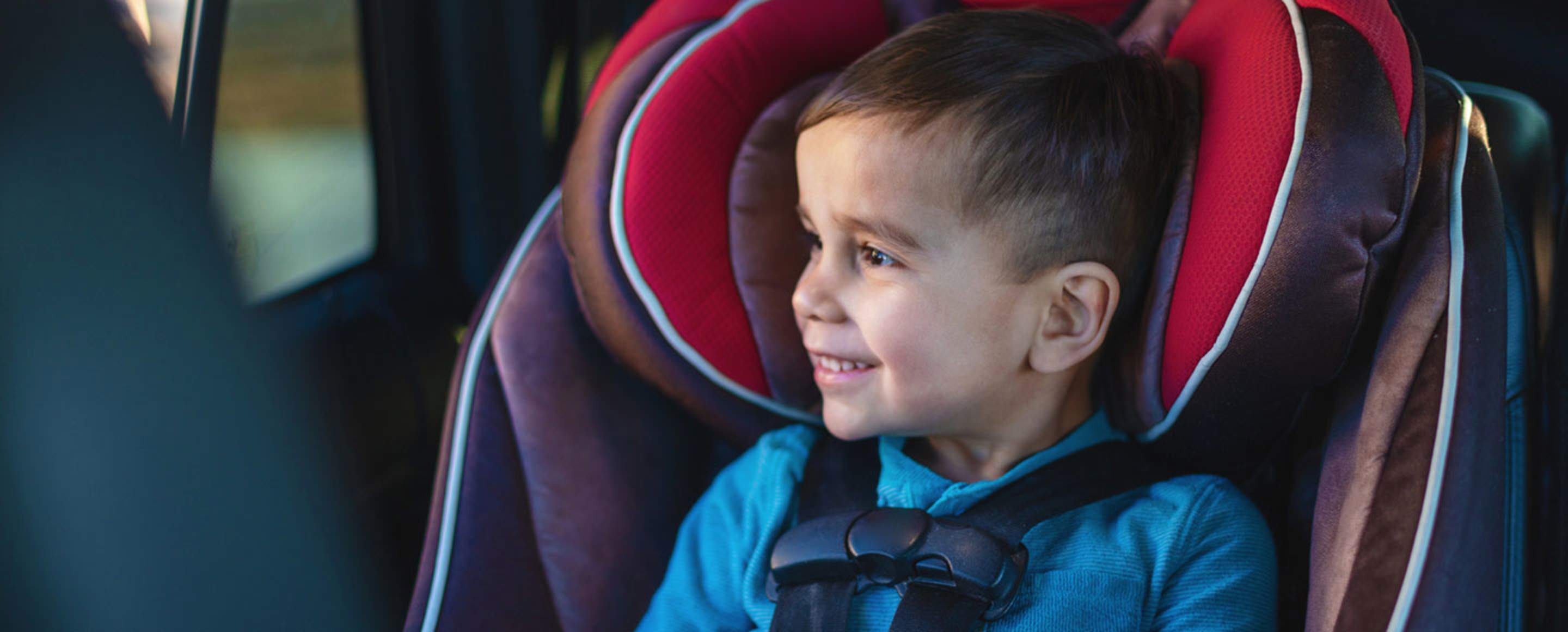 a happy toddler sits in a car seat inspected and installed by a AAA child passenger safety technician