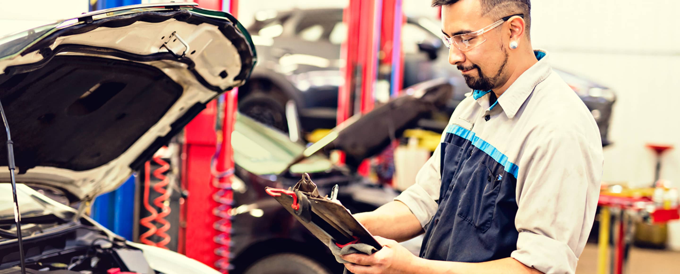 An auto repair technician inspects a AAA Member's car inside a AAA Auto Repair Center