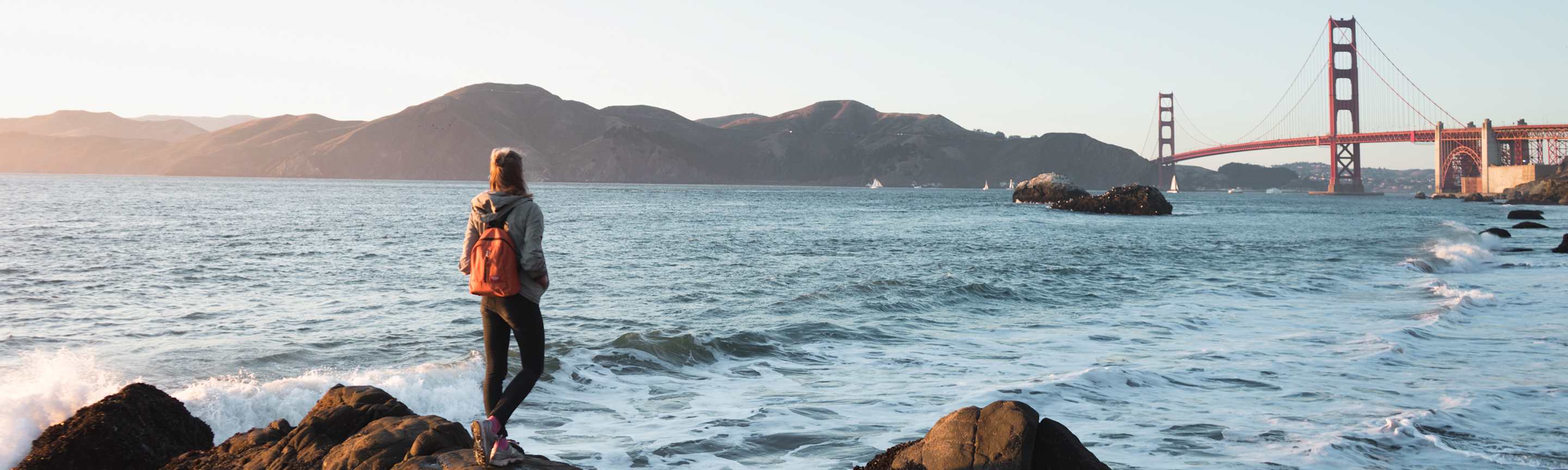 AAA Member stands in front of the Golden Gate Bridge.