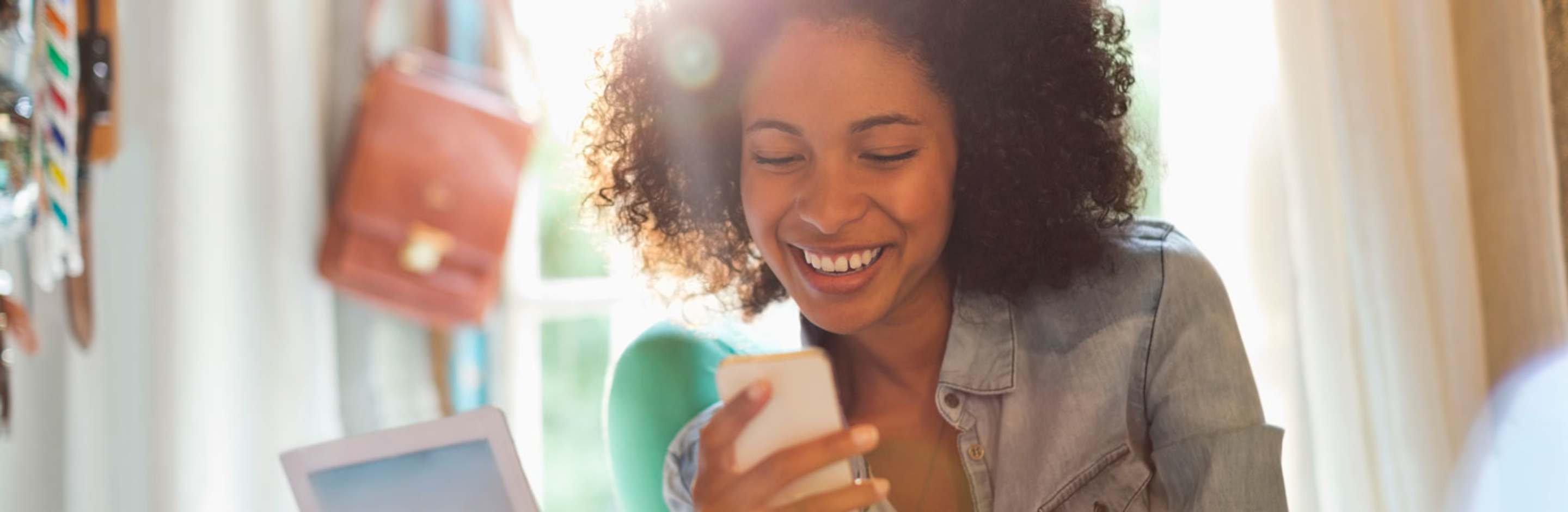 A woman looking at her phone, smiling