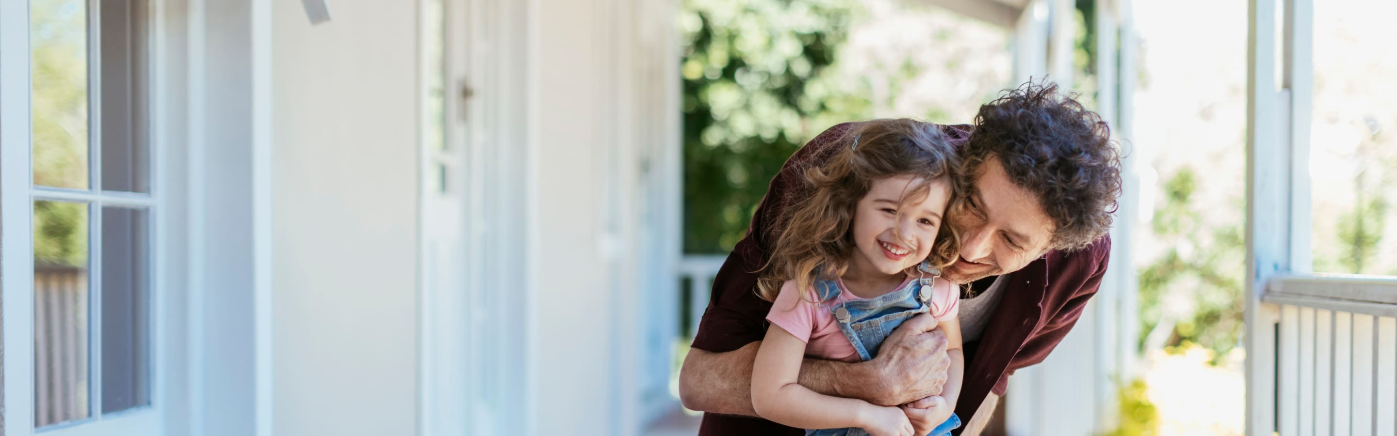 Father hugging daughter on front porch