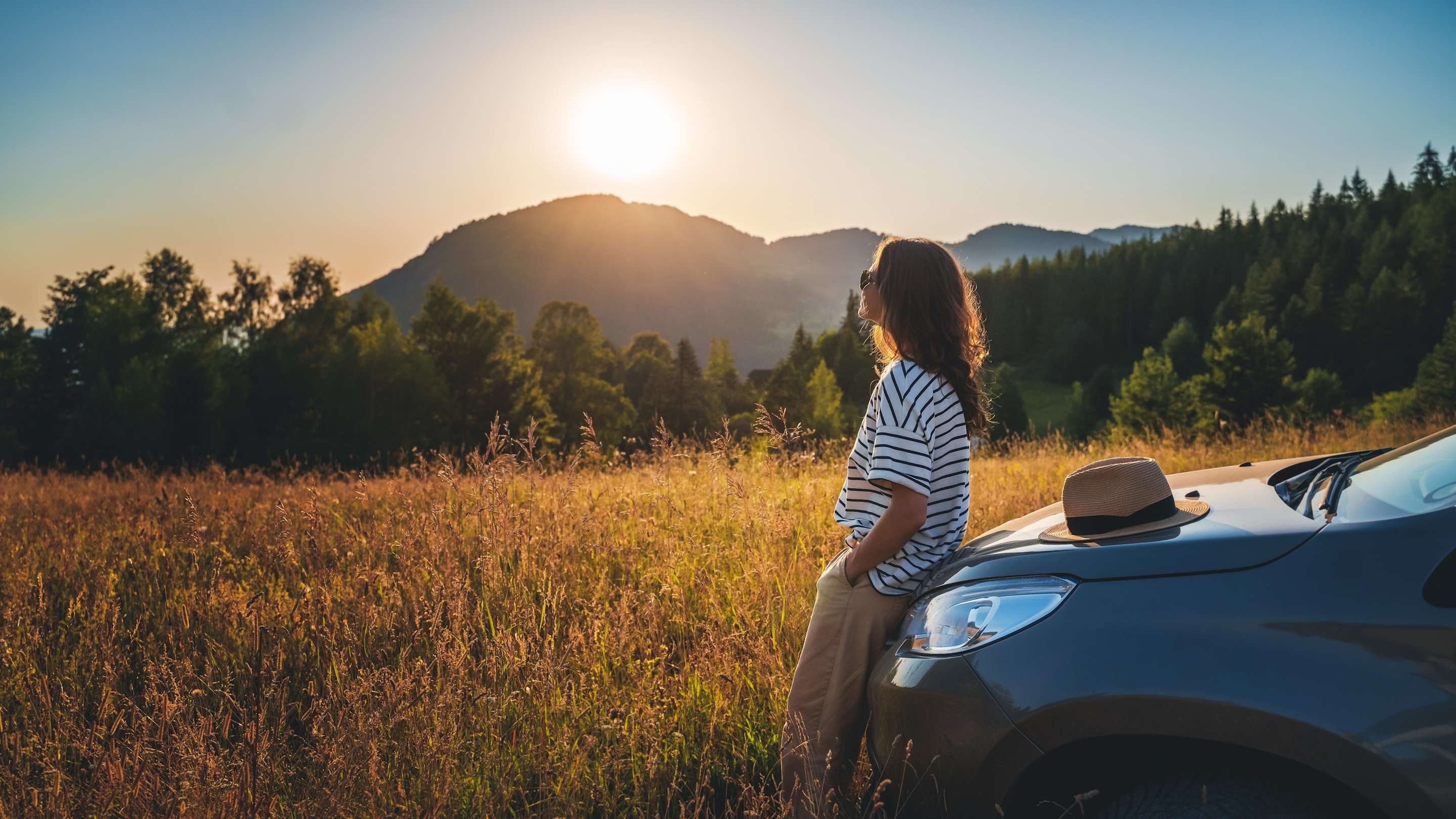 Girl standing by car insured by AAA auto insurance