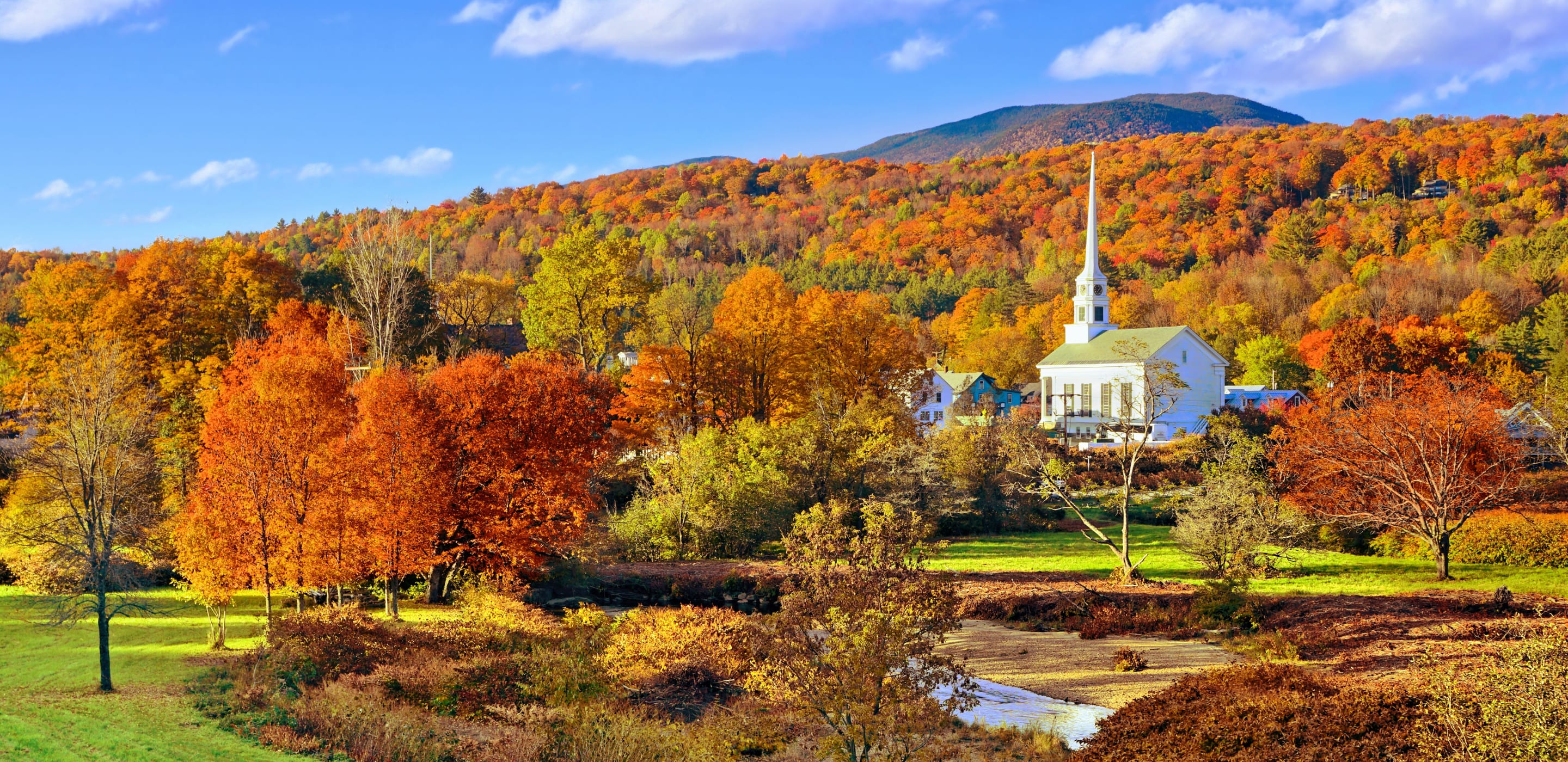 autumn countryside view of the town of stowe, vermont with white church and fall colors