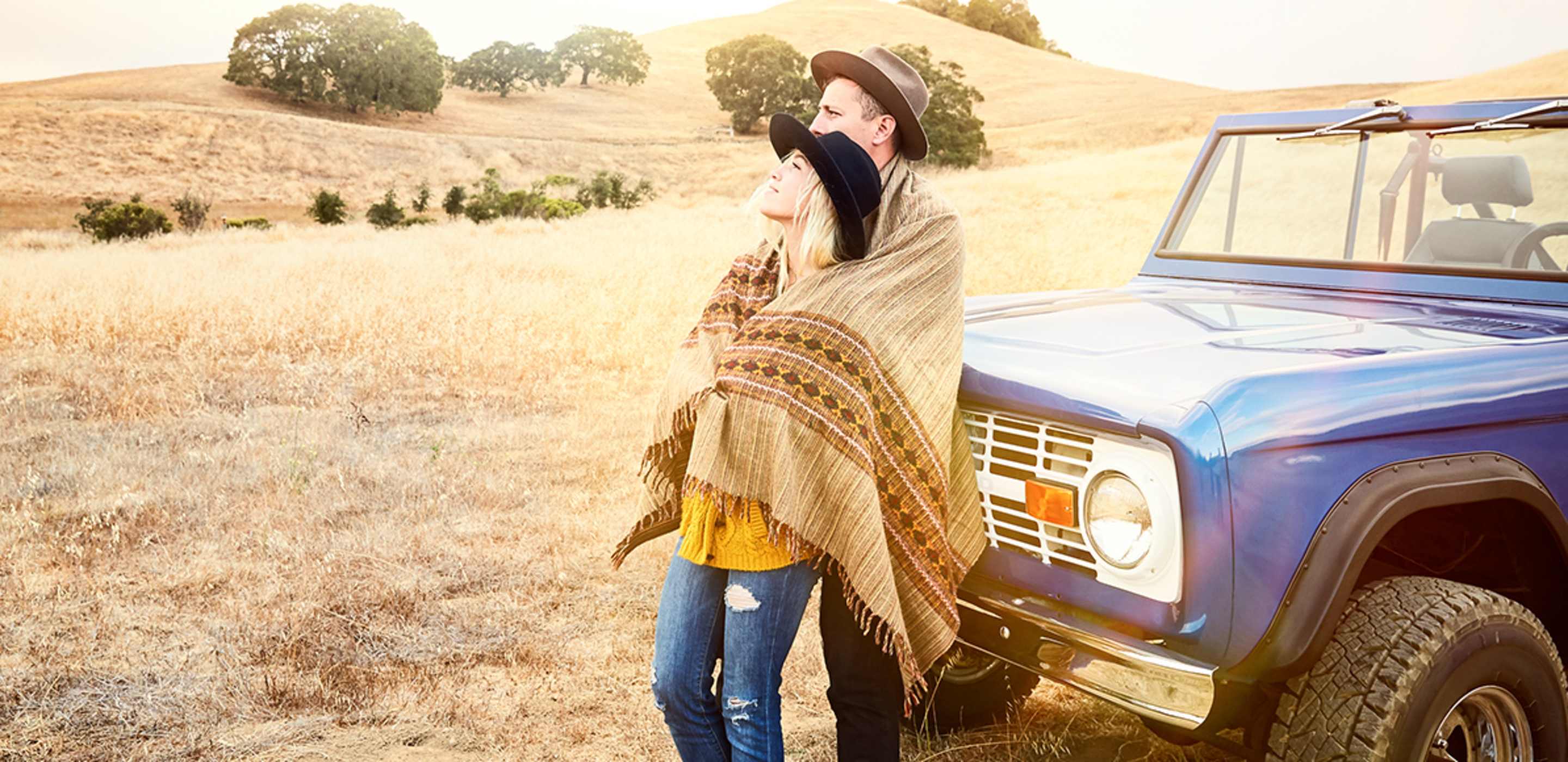 A couple hug outside their car protected by aaa auto insurance